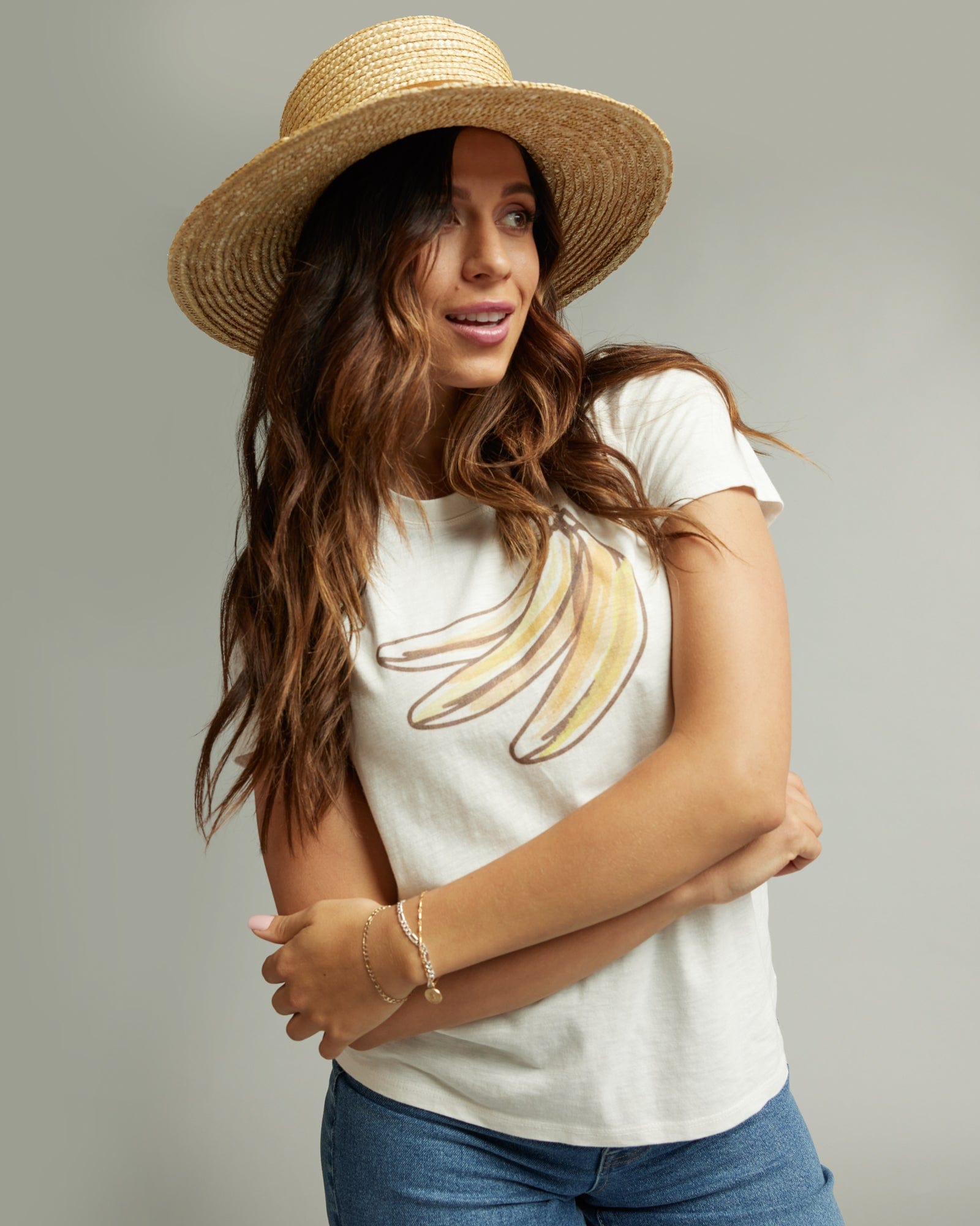 Woman in a short sleeve white graphic tee with a banana on the front
