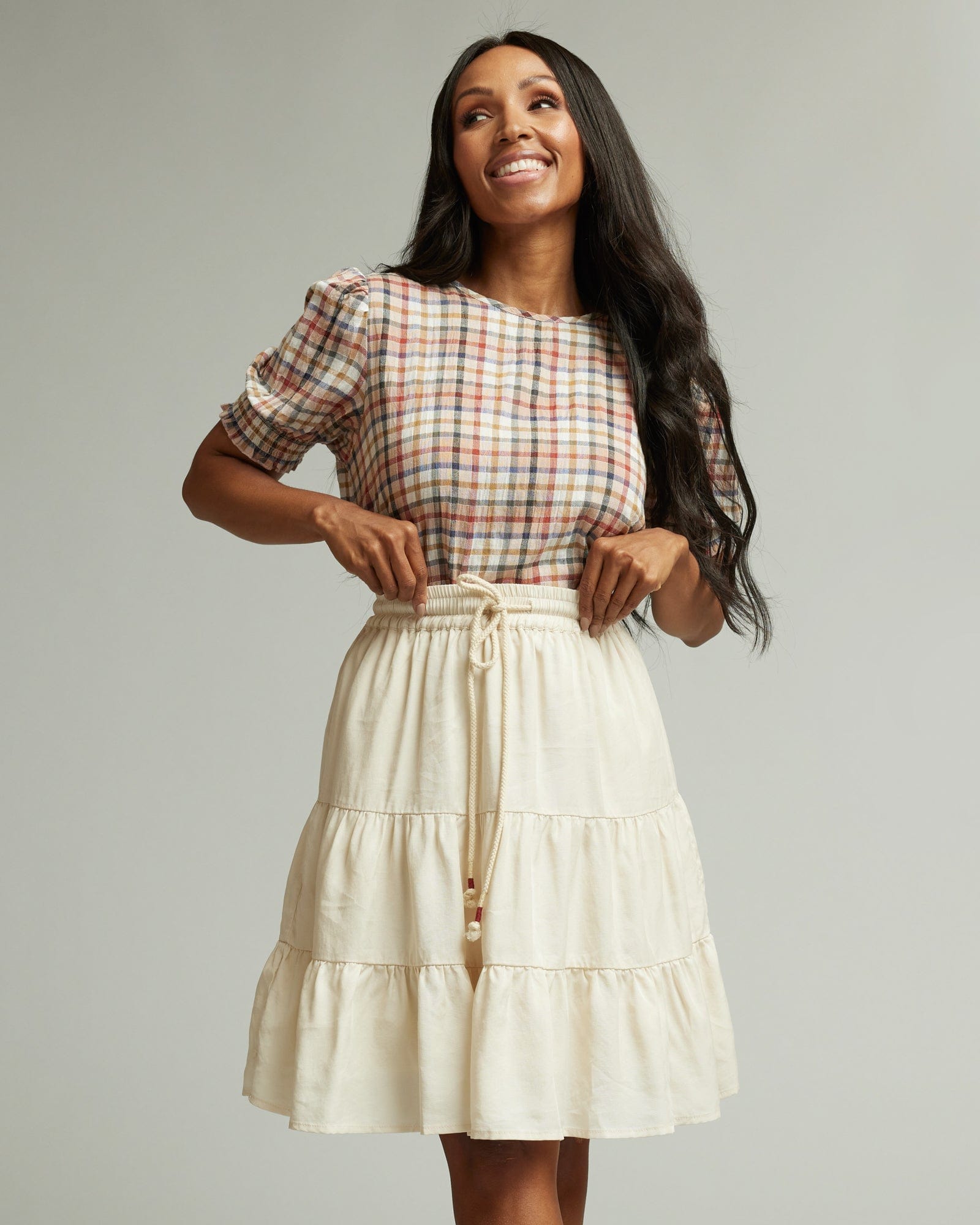 Woman in a white knee-length tiered skirt