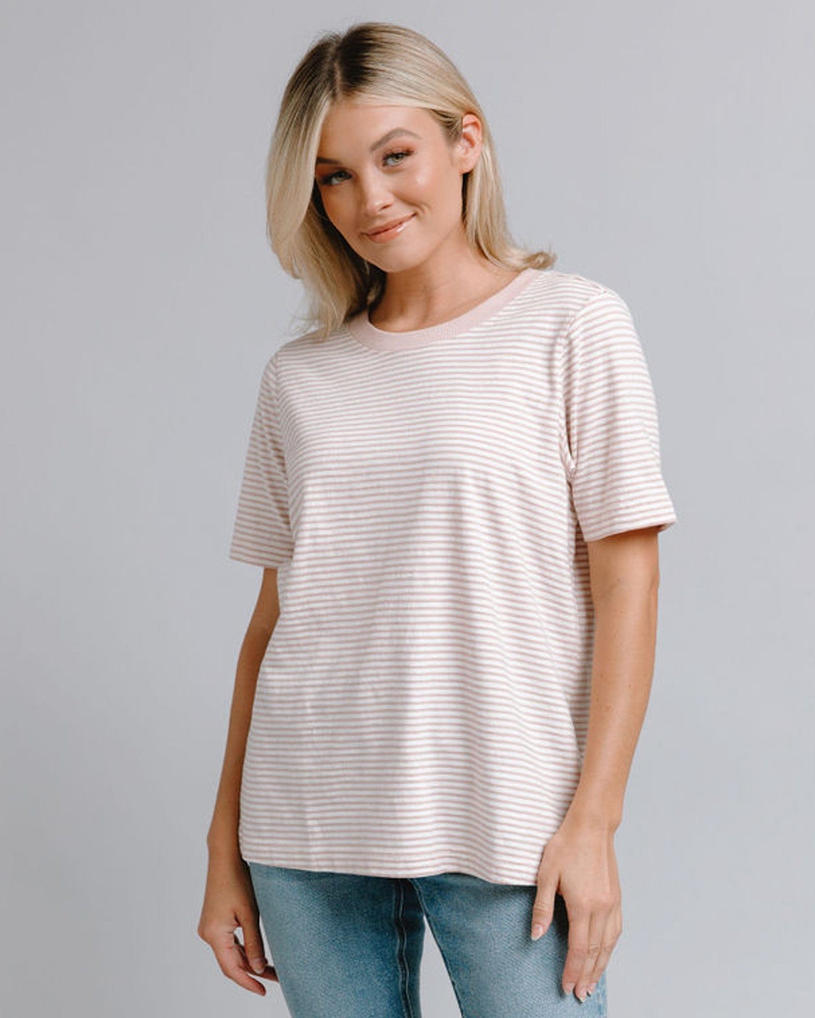 Woman in a shosrt sleeve, loose fit, pink striped tshirt