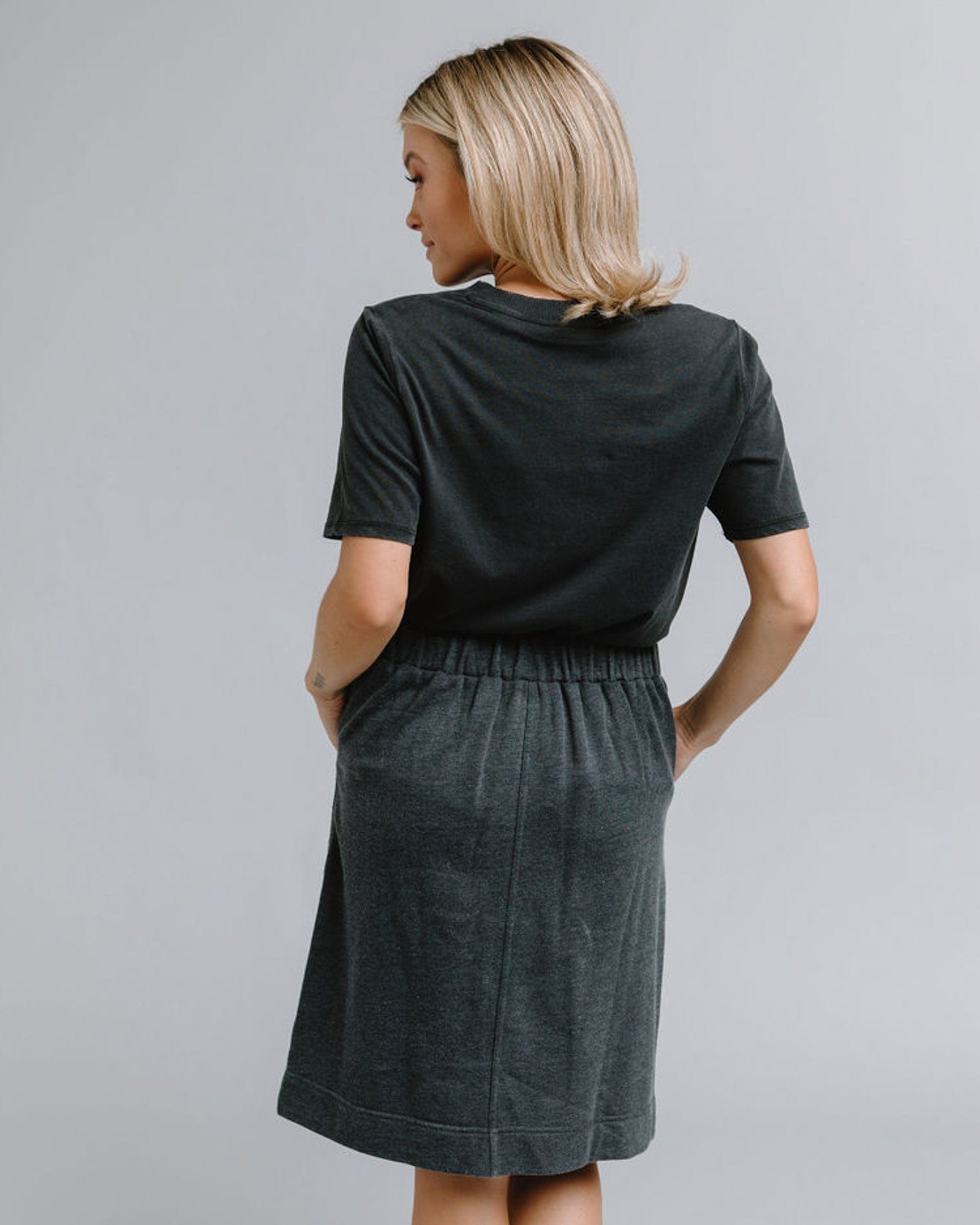 Woman in a gray knee-length skirt with pockets
