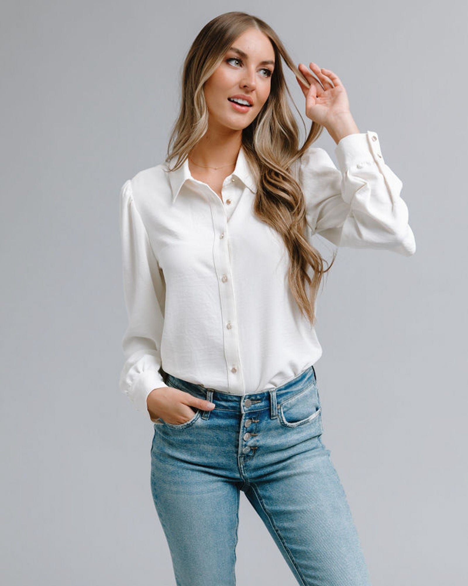 Woman in a long sleeve, collared, white button-down blouse