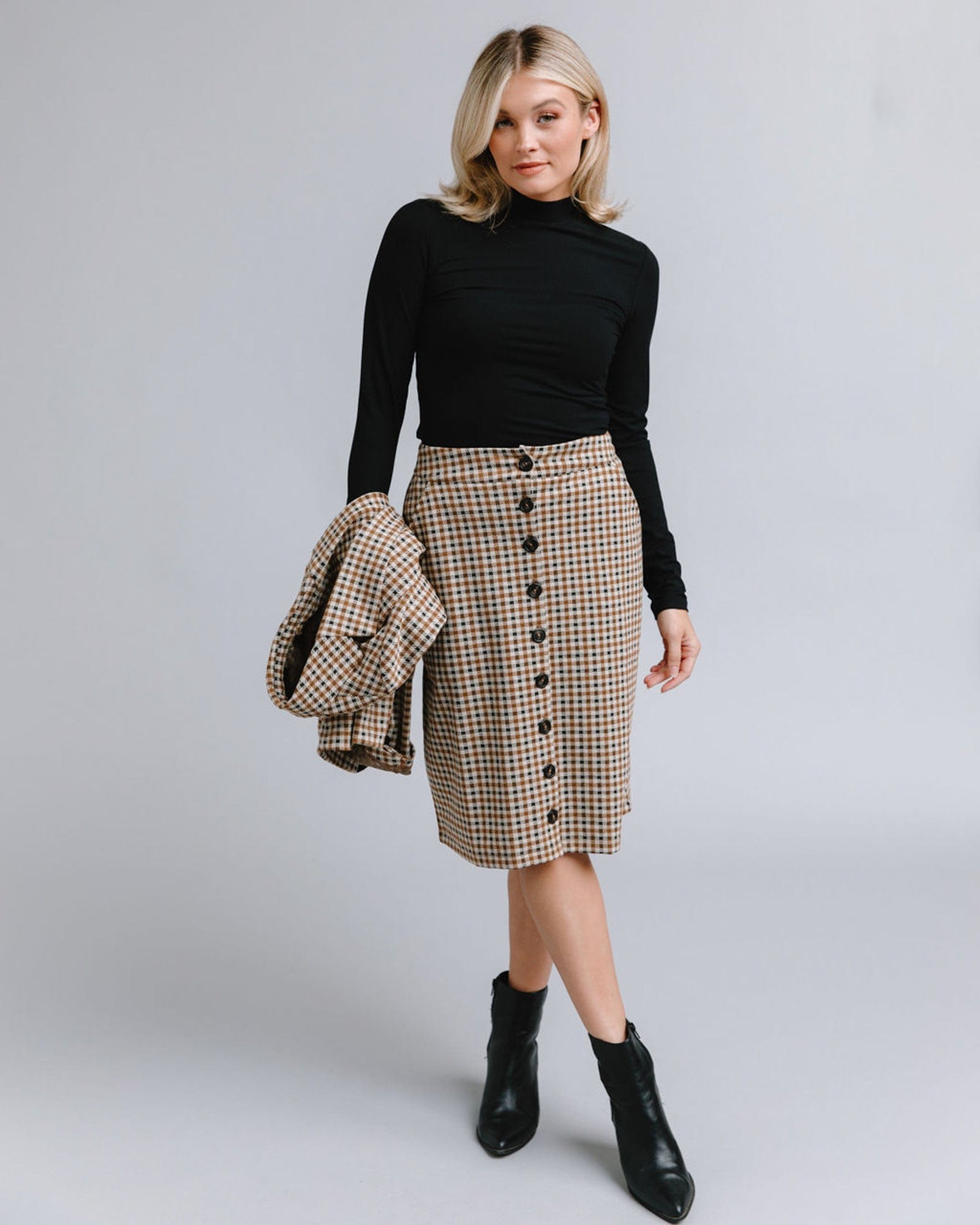 Woman in a knee-length plaid button-down skirt