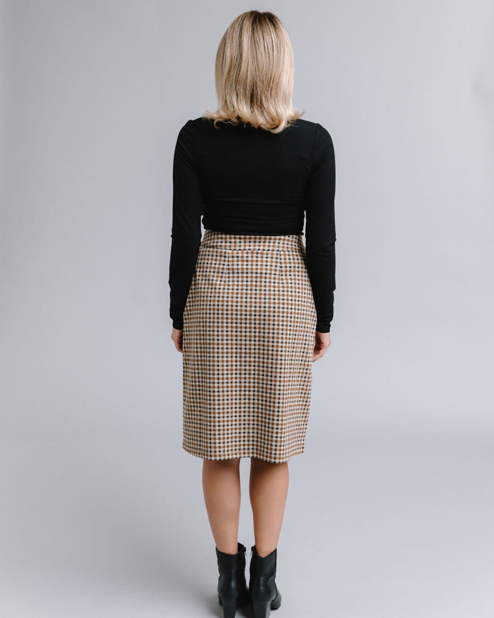 Woman in a knee-length plaid button-down skirt