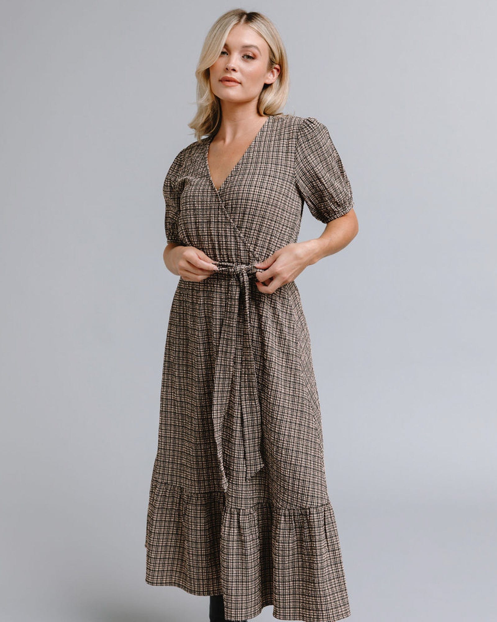 Woman in a short sleeve, midi-length, plaid dress