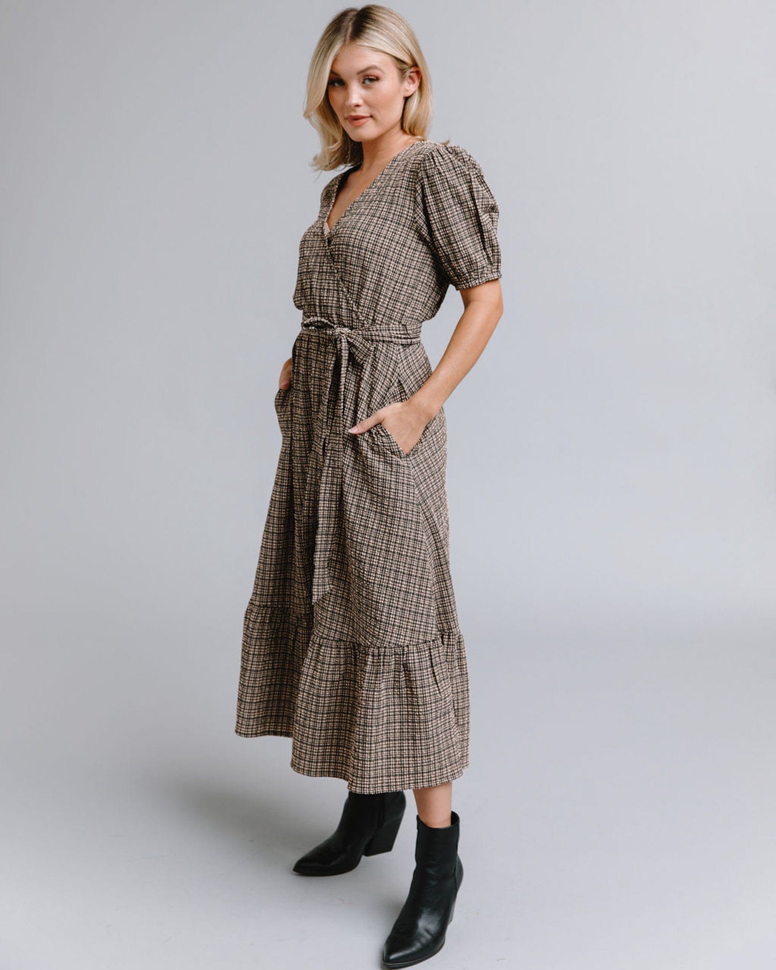 Woman in a short sleeve, midi-length, plaid dress