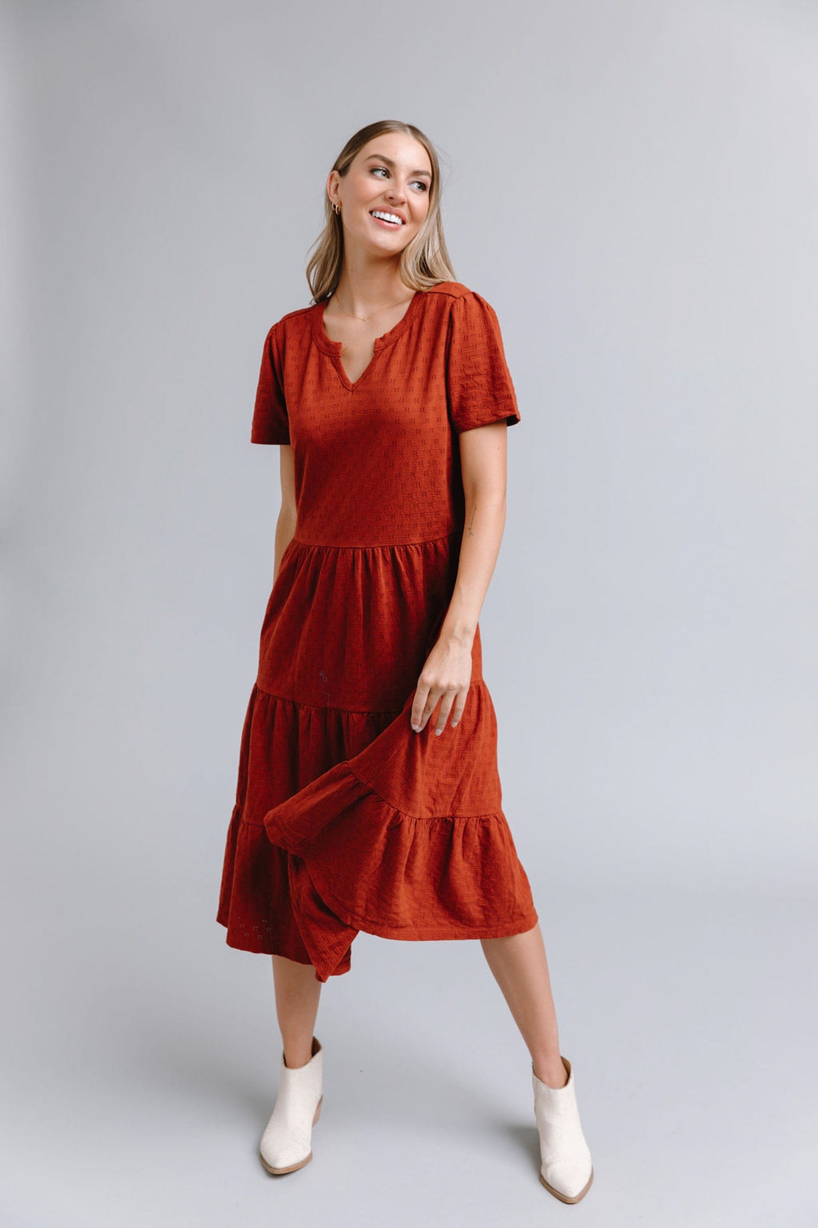 Woman in a short sleeve, midi-length with tiered skirt dress