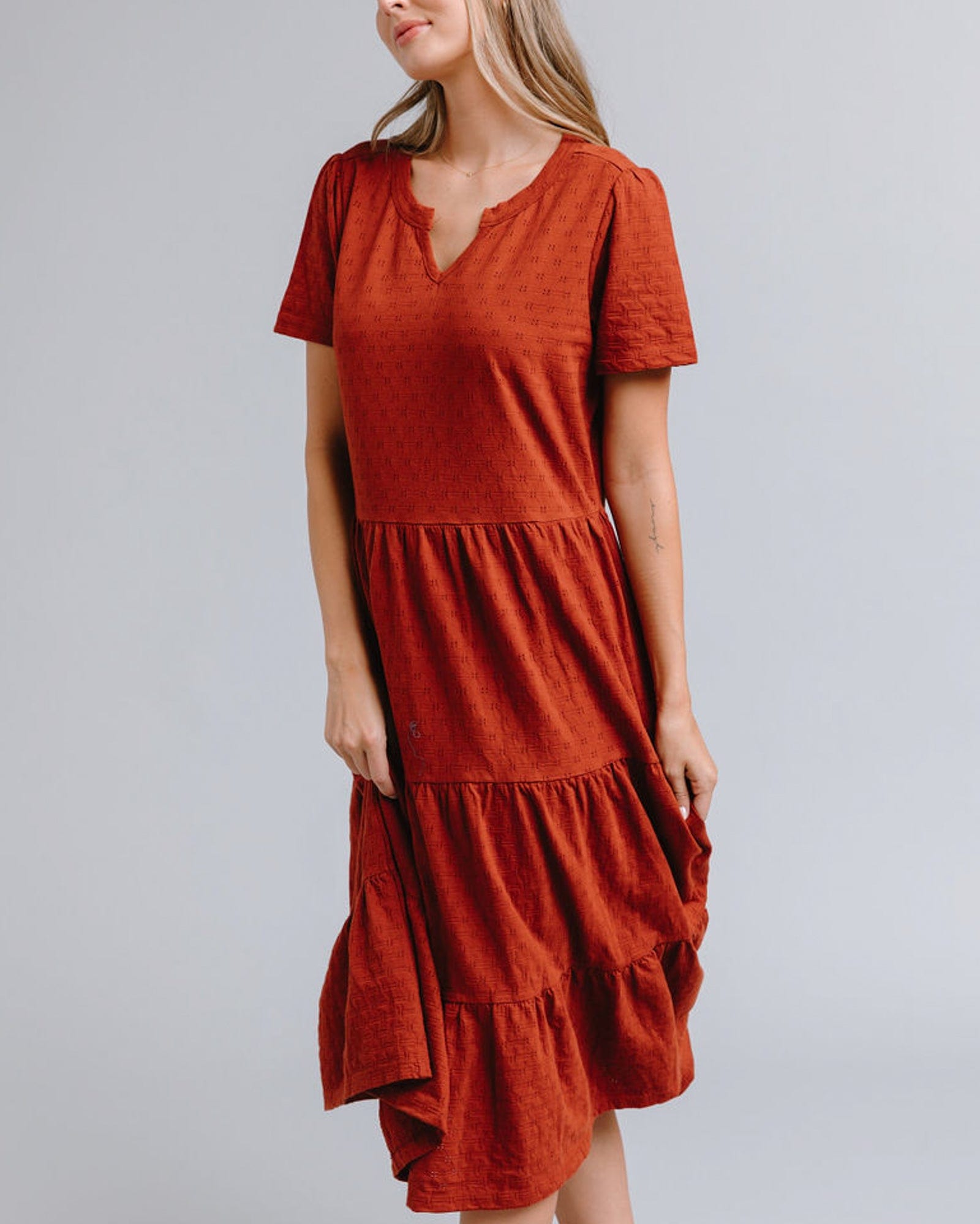 Woman in a short sleeve, midi-length with tiered skirt dress