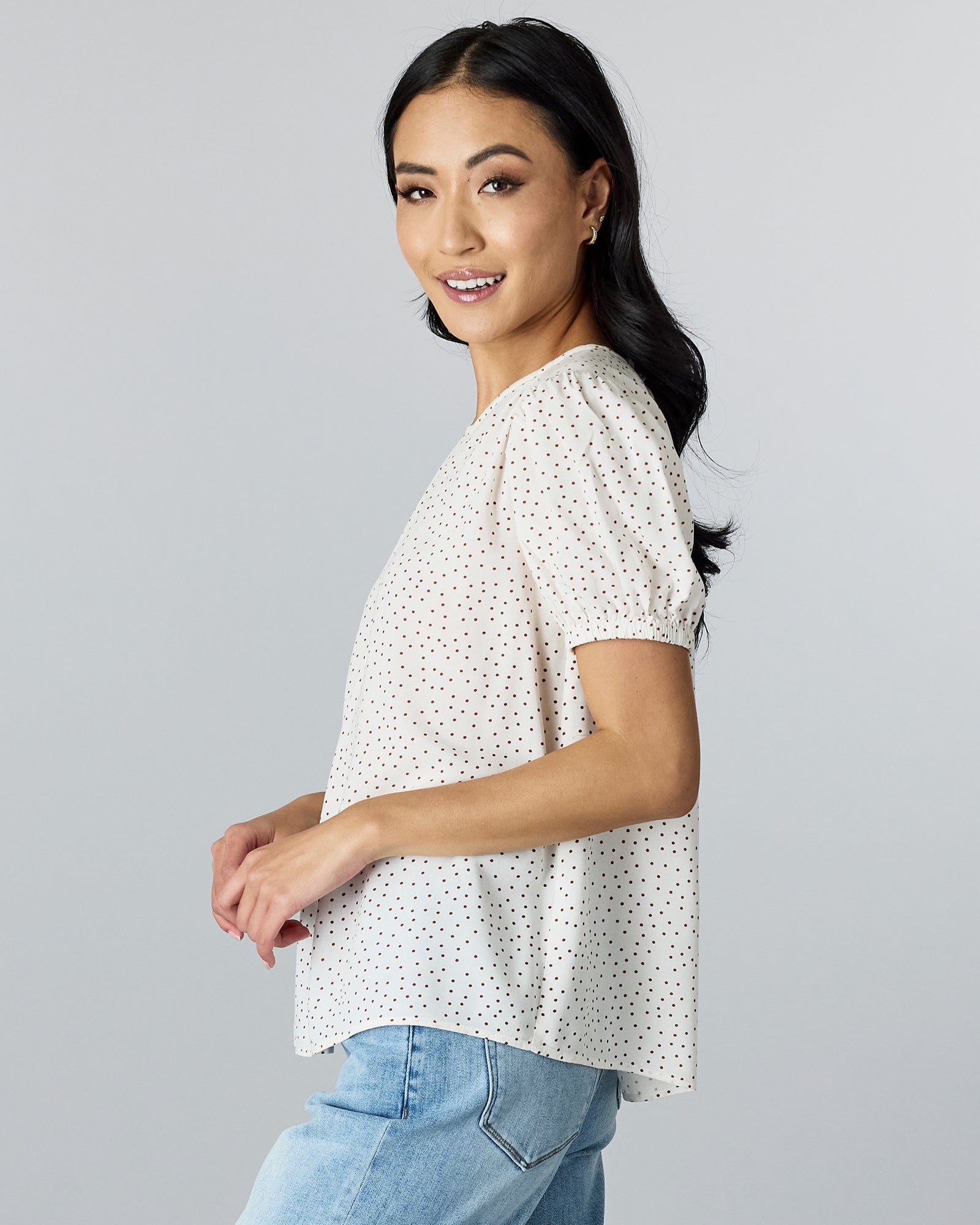 Woman in a short sleeve polka dotted blouse. 