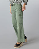 Woman in floor length green cargo jeans.