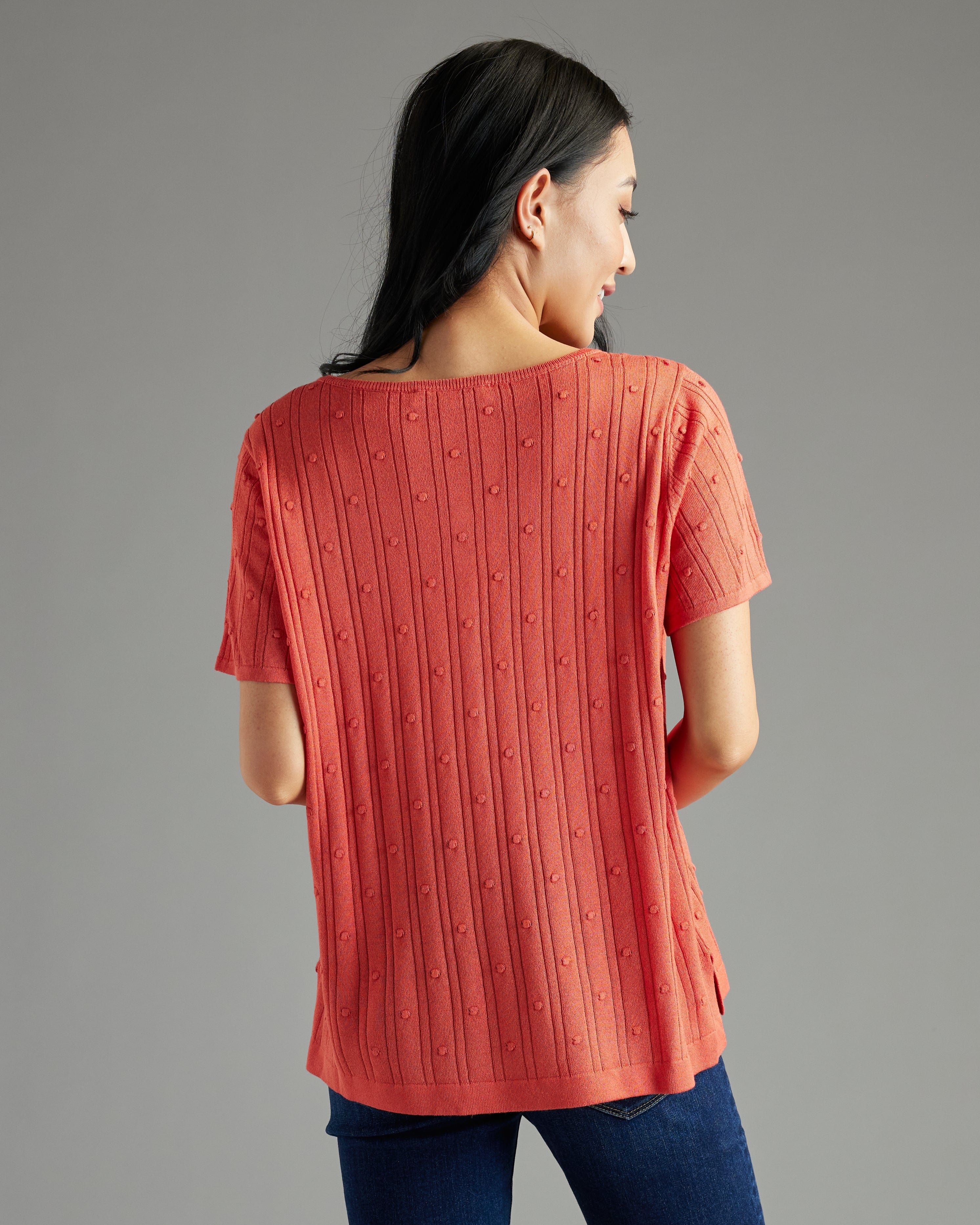 Woman in orange short sleeve textured sweater