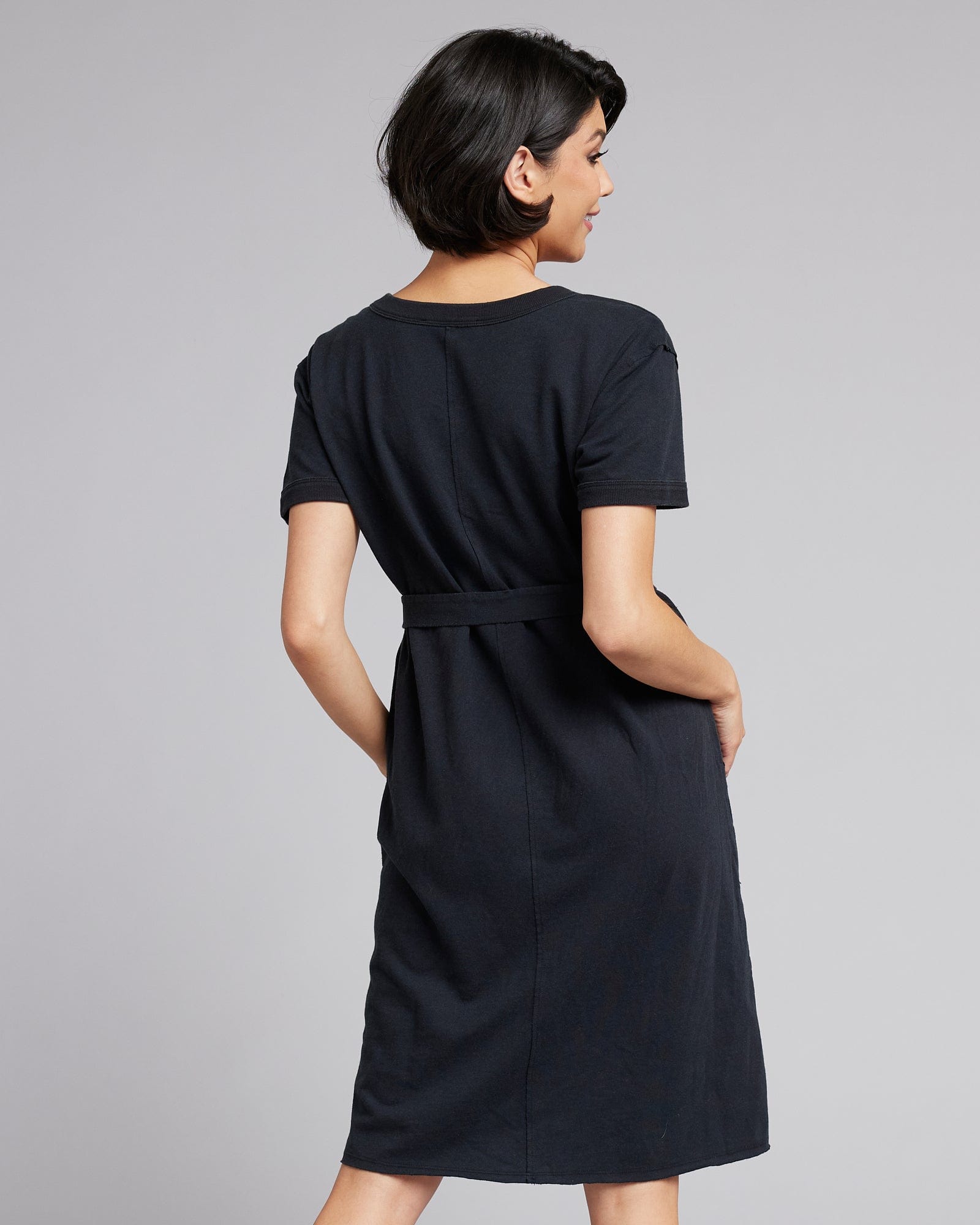 Woman in a short sleeve, knee-length, v-neck black dress