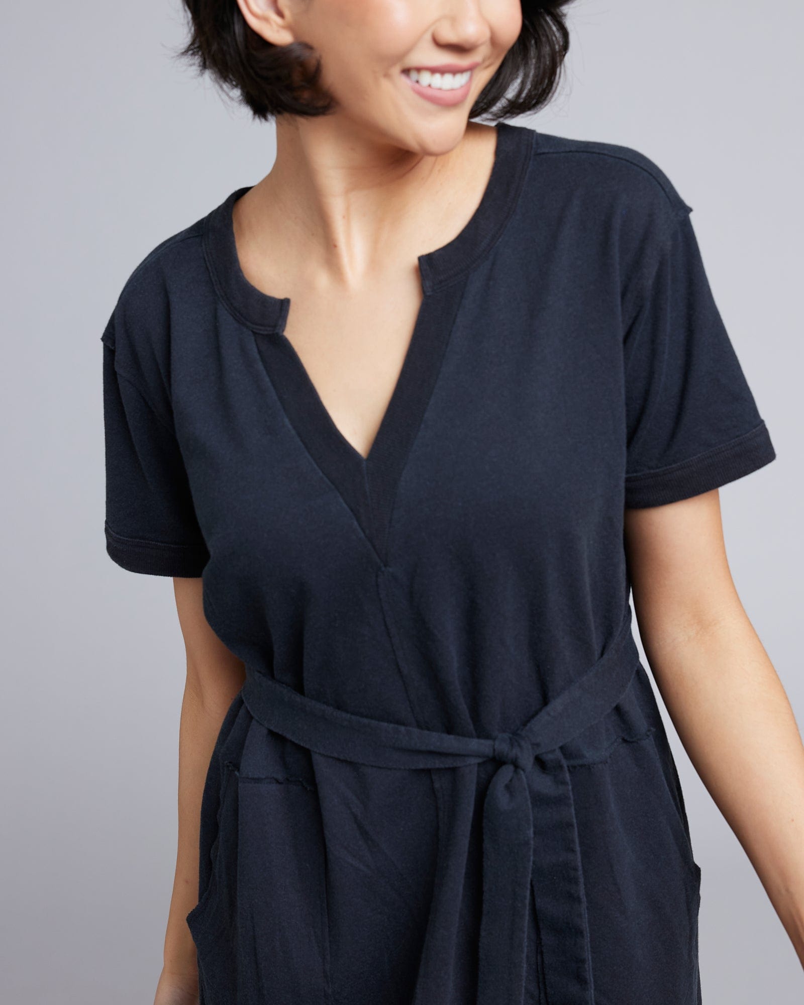 Woman in a short sleeve, knee-length, v-neck black dress