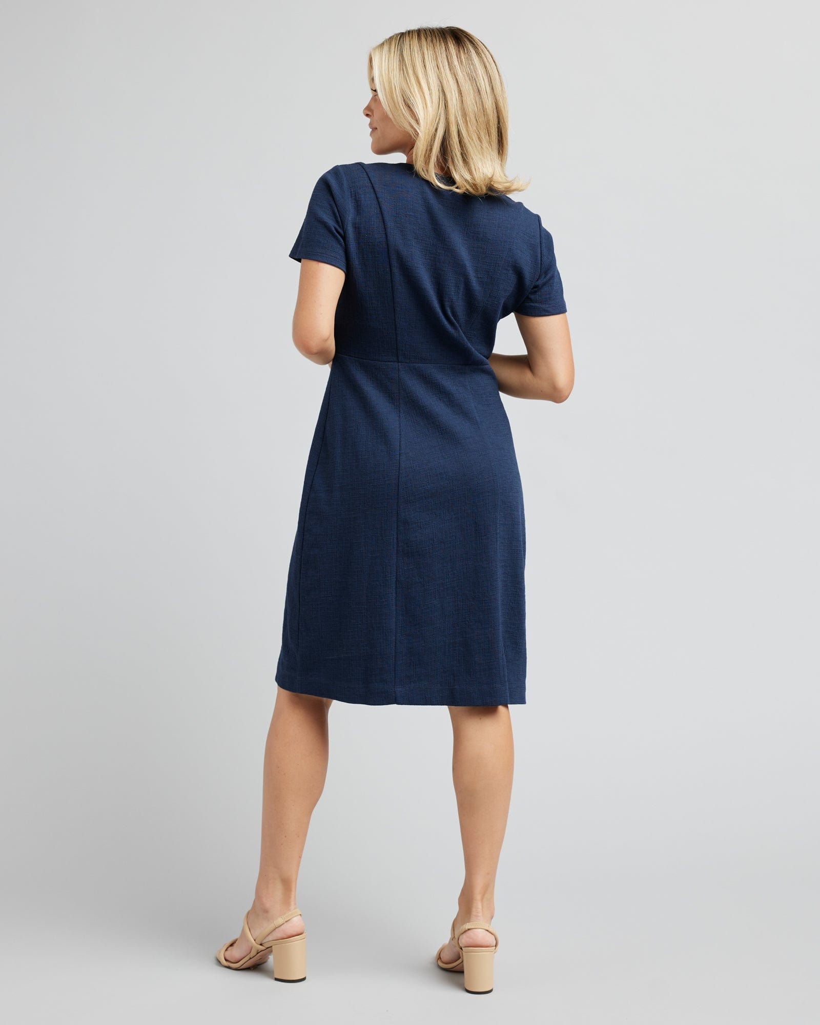 Woman in a short sleeve, knee-length, navy dress
