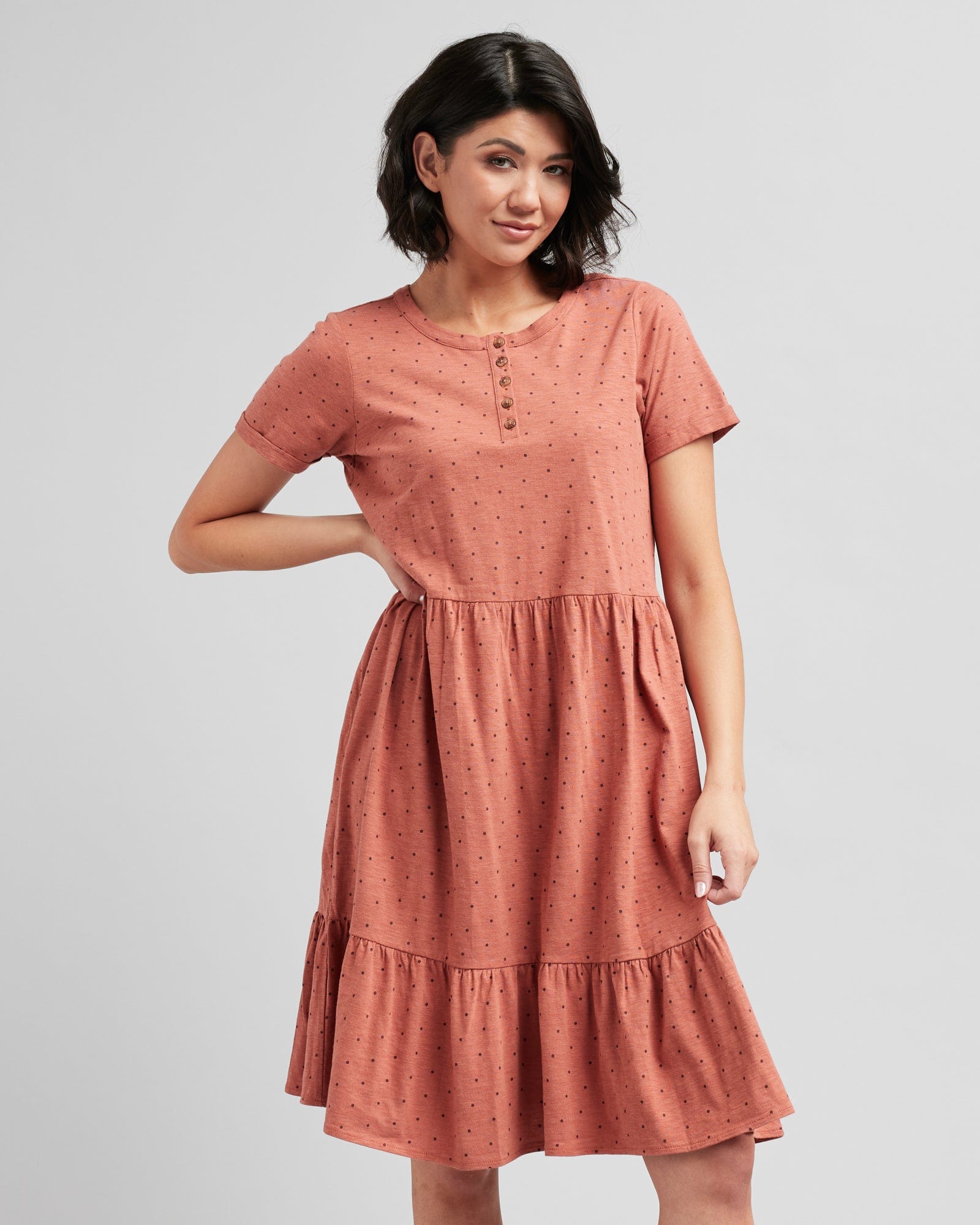 Woman in a short sleeve, henley top, dotted swiss, orange dress