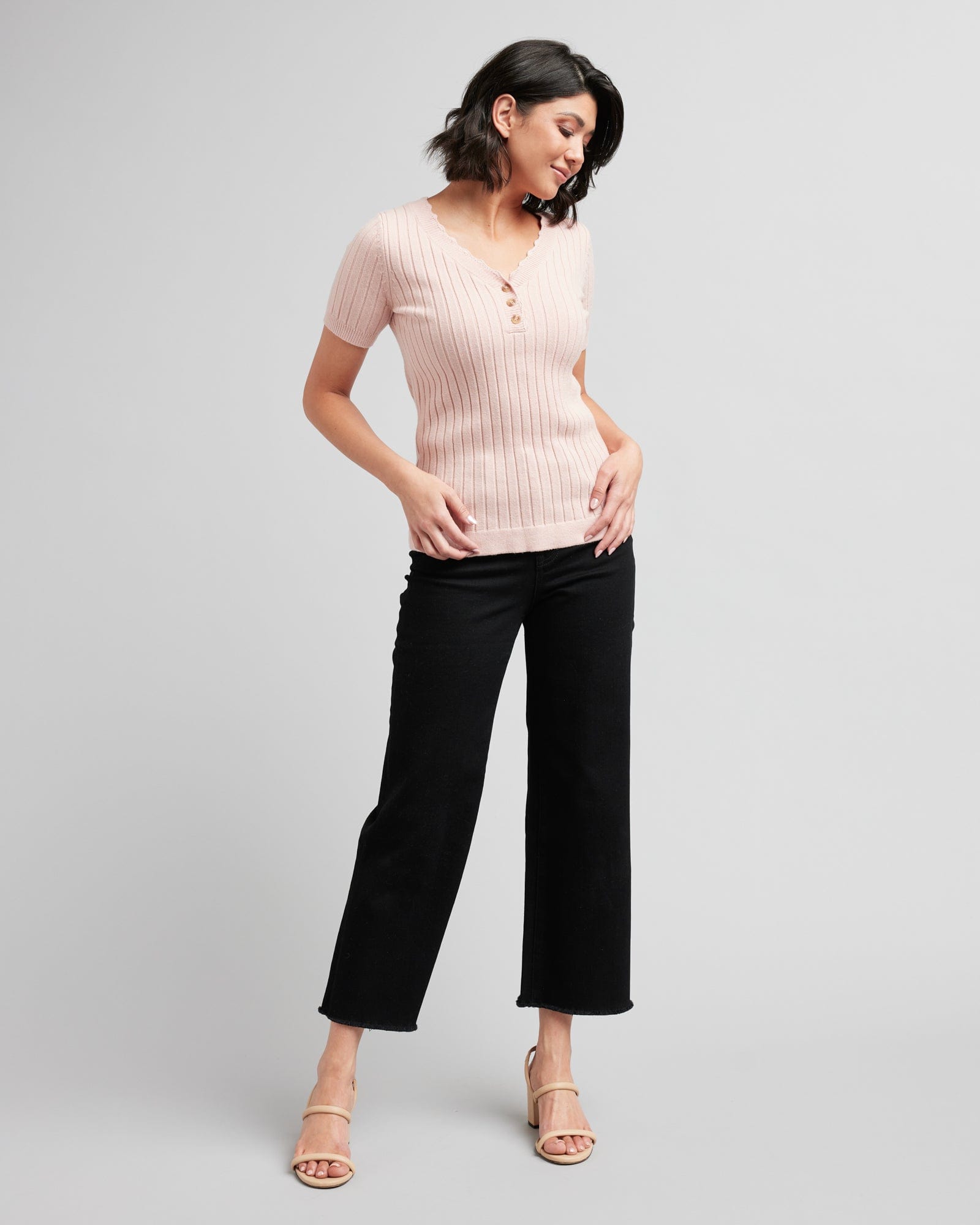 Woman in a pink ribbed short sleeve sweater