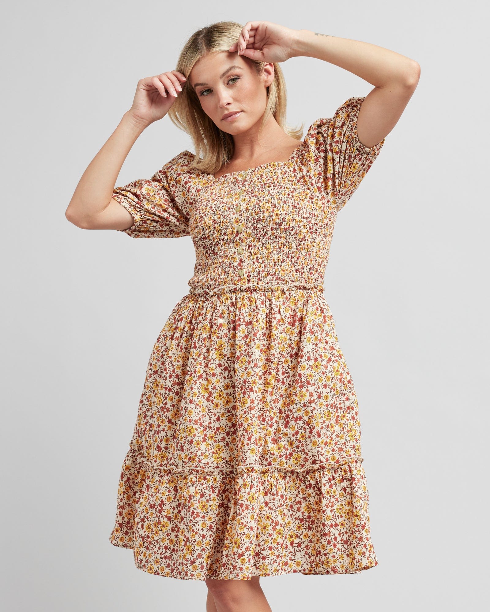 Woman in a short puffed sleeve, knee-length, floral printed dress