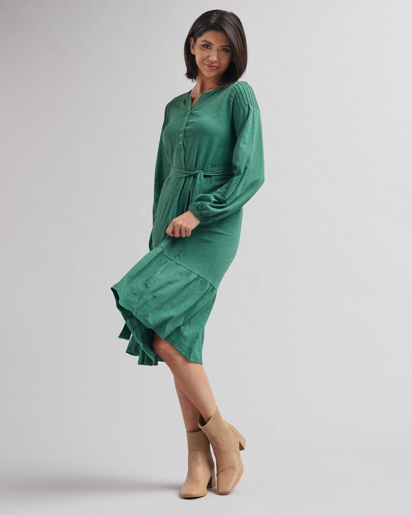Woman in a long sleeve, midi-length, green dress