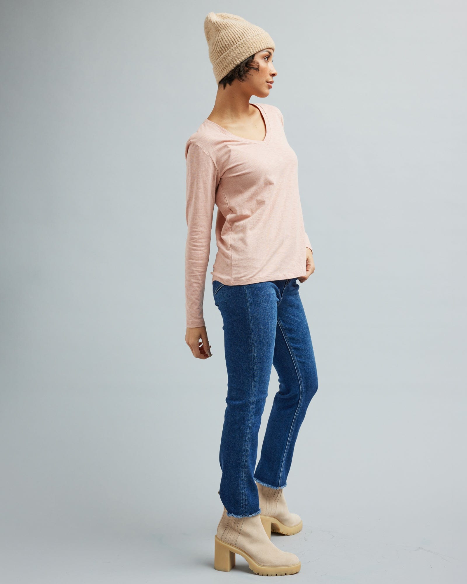 Woman in a long sleeve, pink v-neck t-shirt