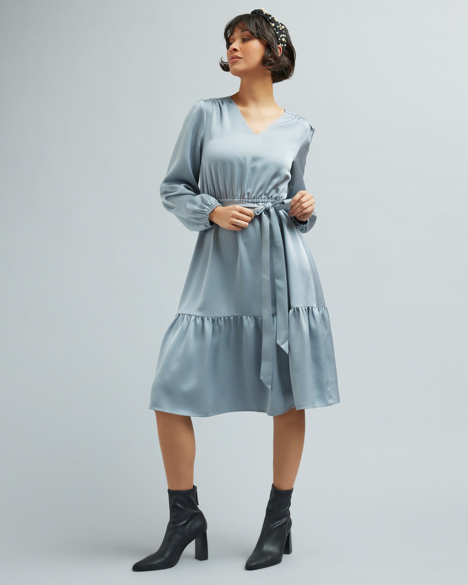 Woman in a long sleeve, knee-length blue dress