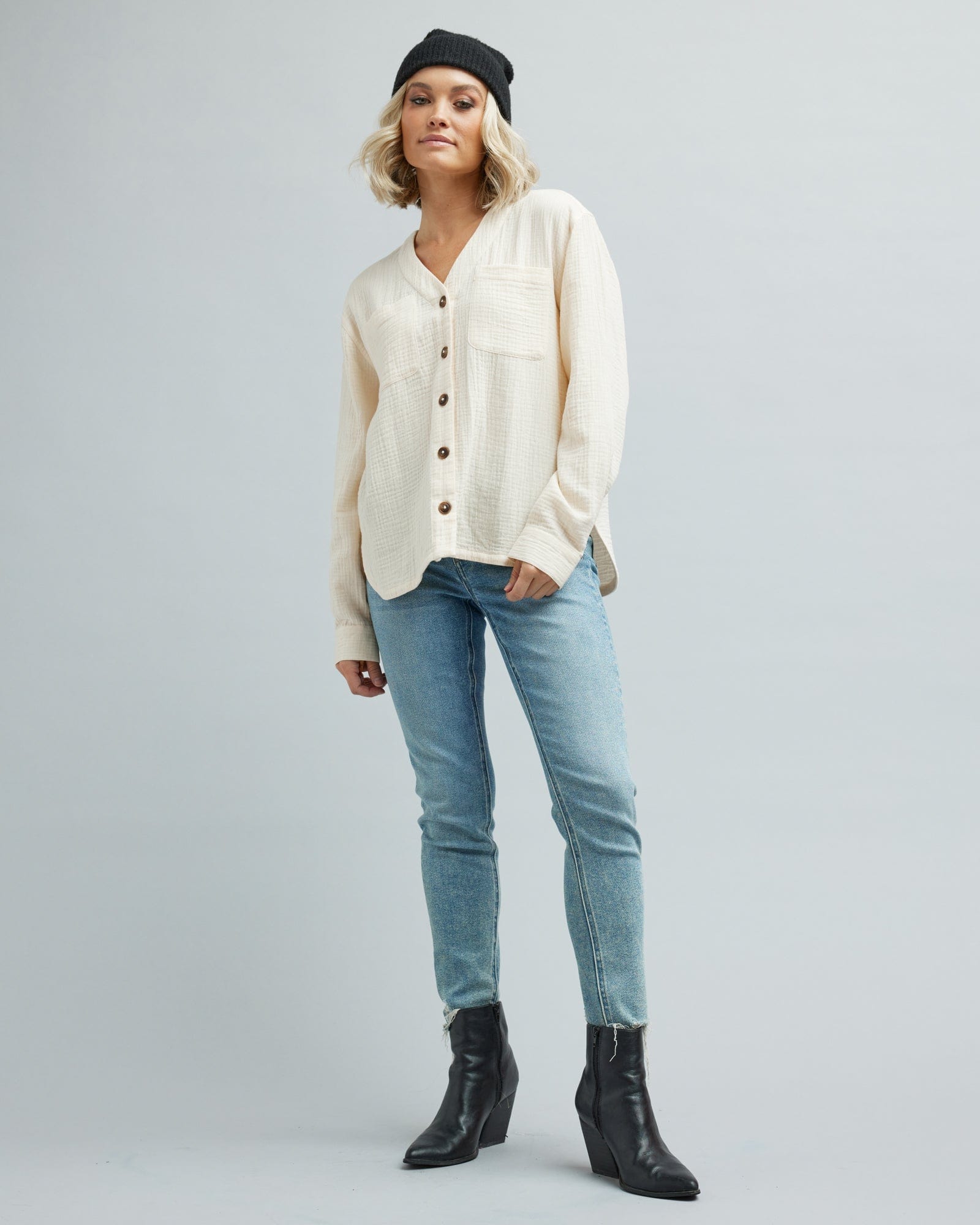 Woman in a long sleeve, white, button-down textured blouse