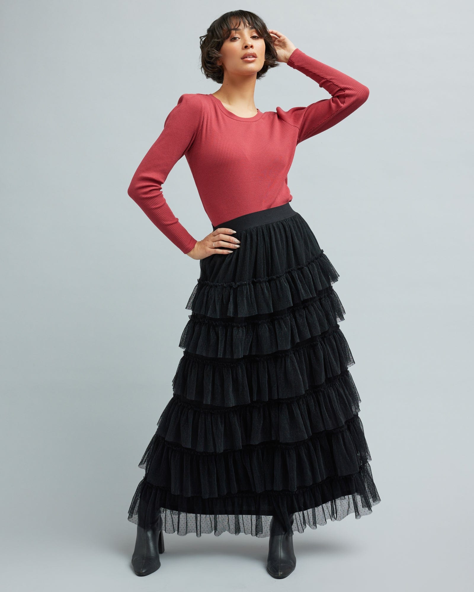 Woman in a black, max-length, ruffled skirt