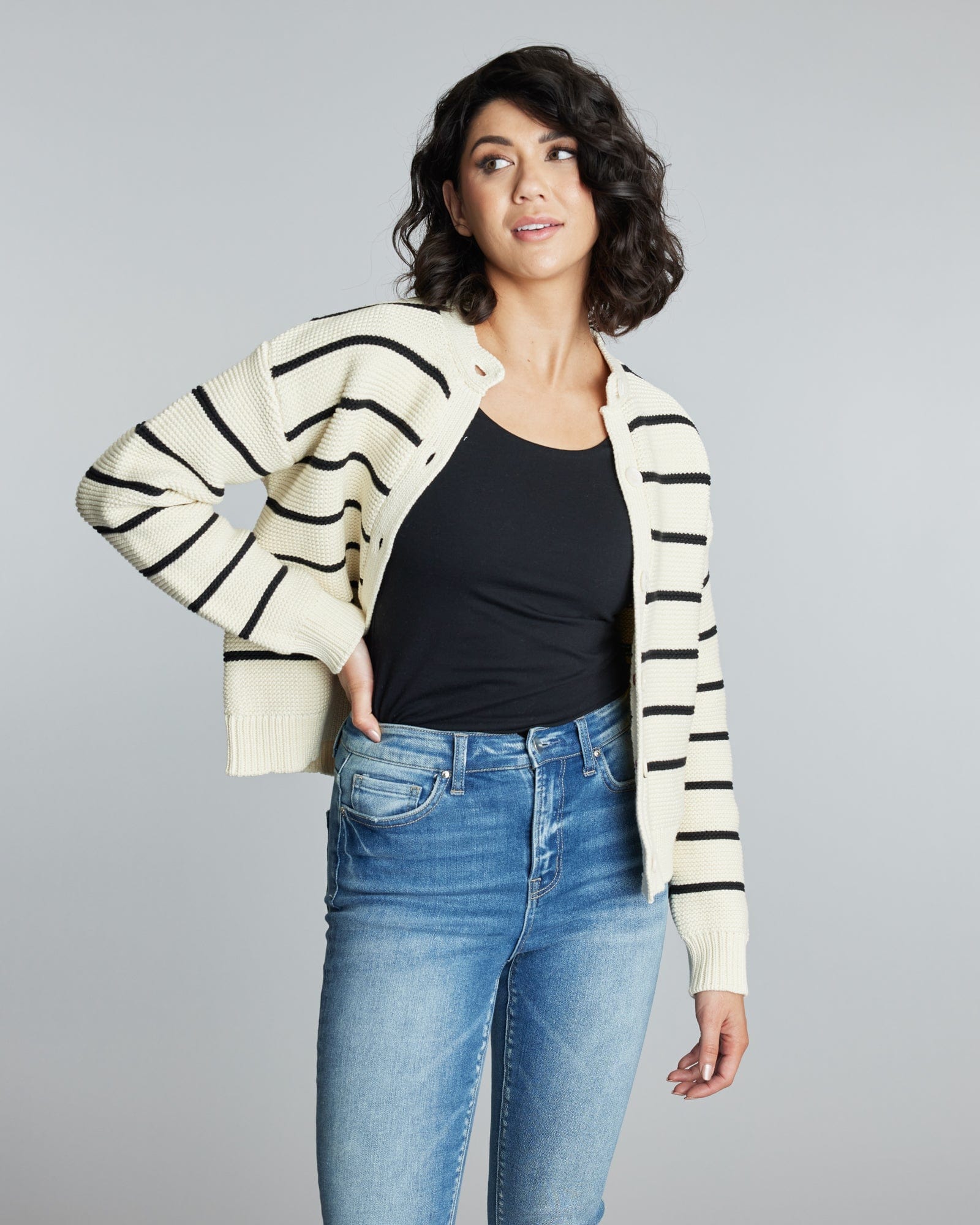 Woman in a long sleeve, black and white striped cardigan