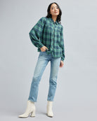 Woman in a collared, blue and green plaid, long sleeve blouse