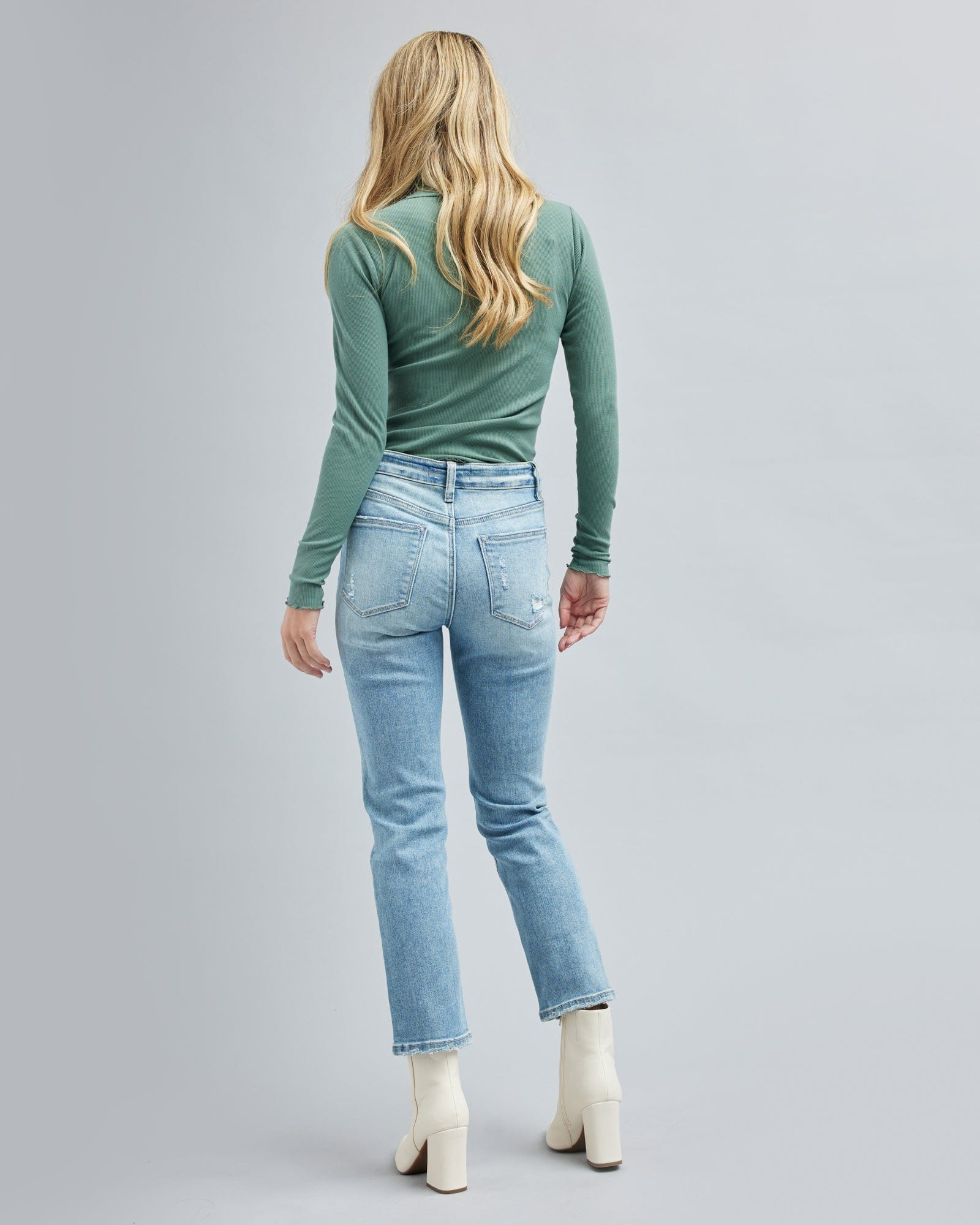 Woman in light blue jean, ankle length jean pants.