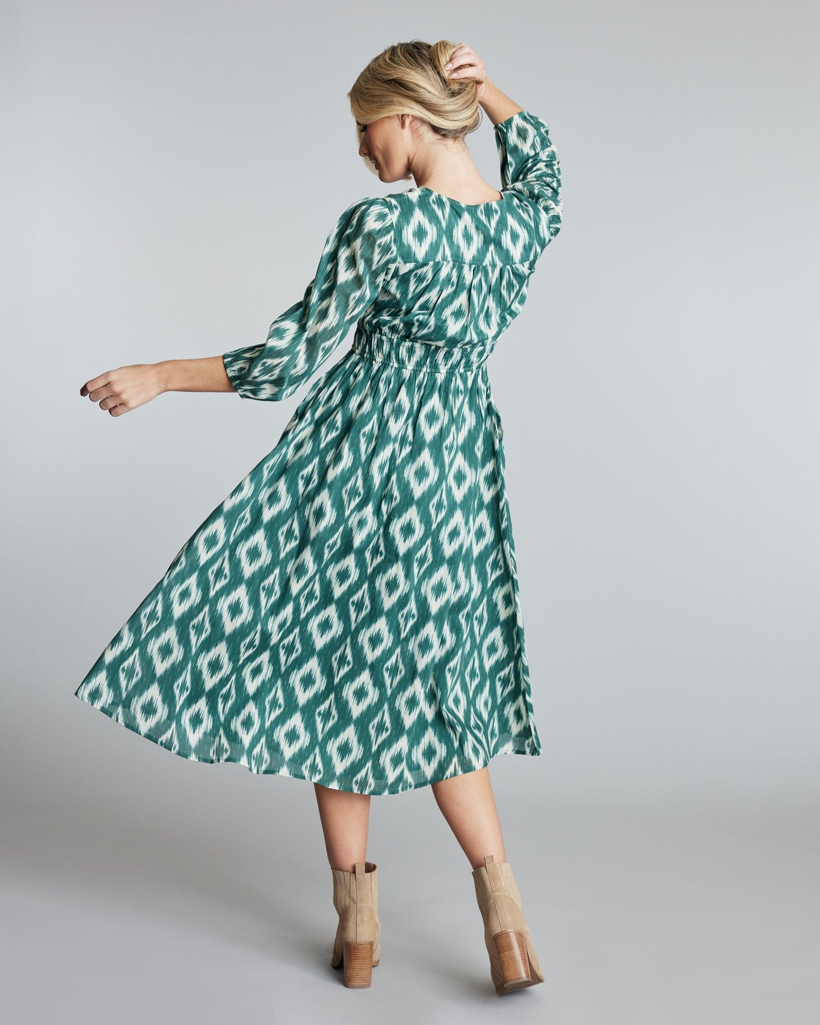 Woman wearing a green geometric print dress