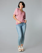 Woman in a short flutter sleee, v-neck, pink with white polka dots top.