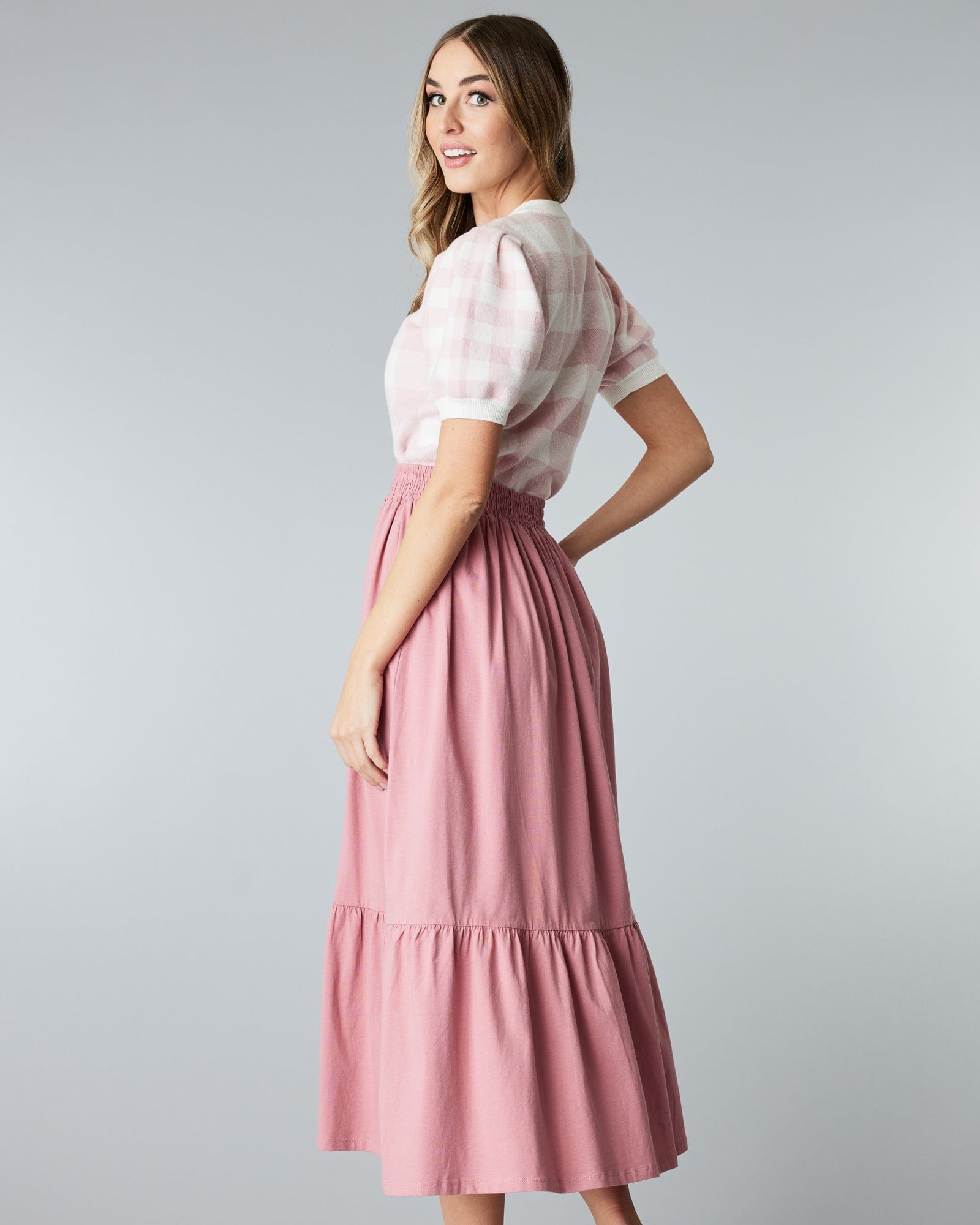 Woman in a pink, tiered, midi skirt