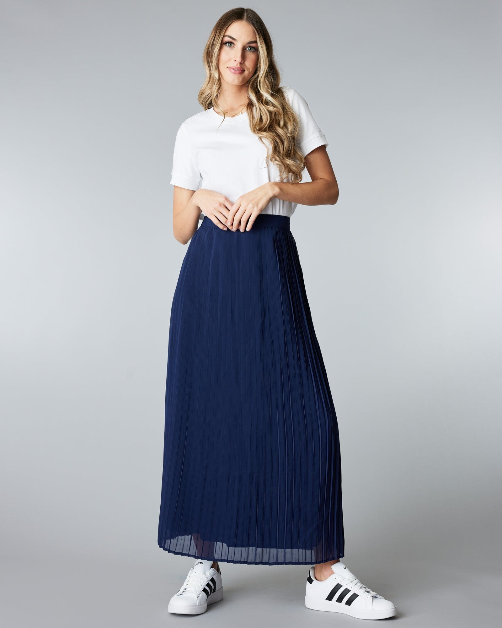 Woman in a maxi length, navy, pleated skirt
