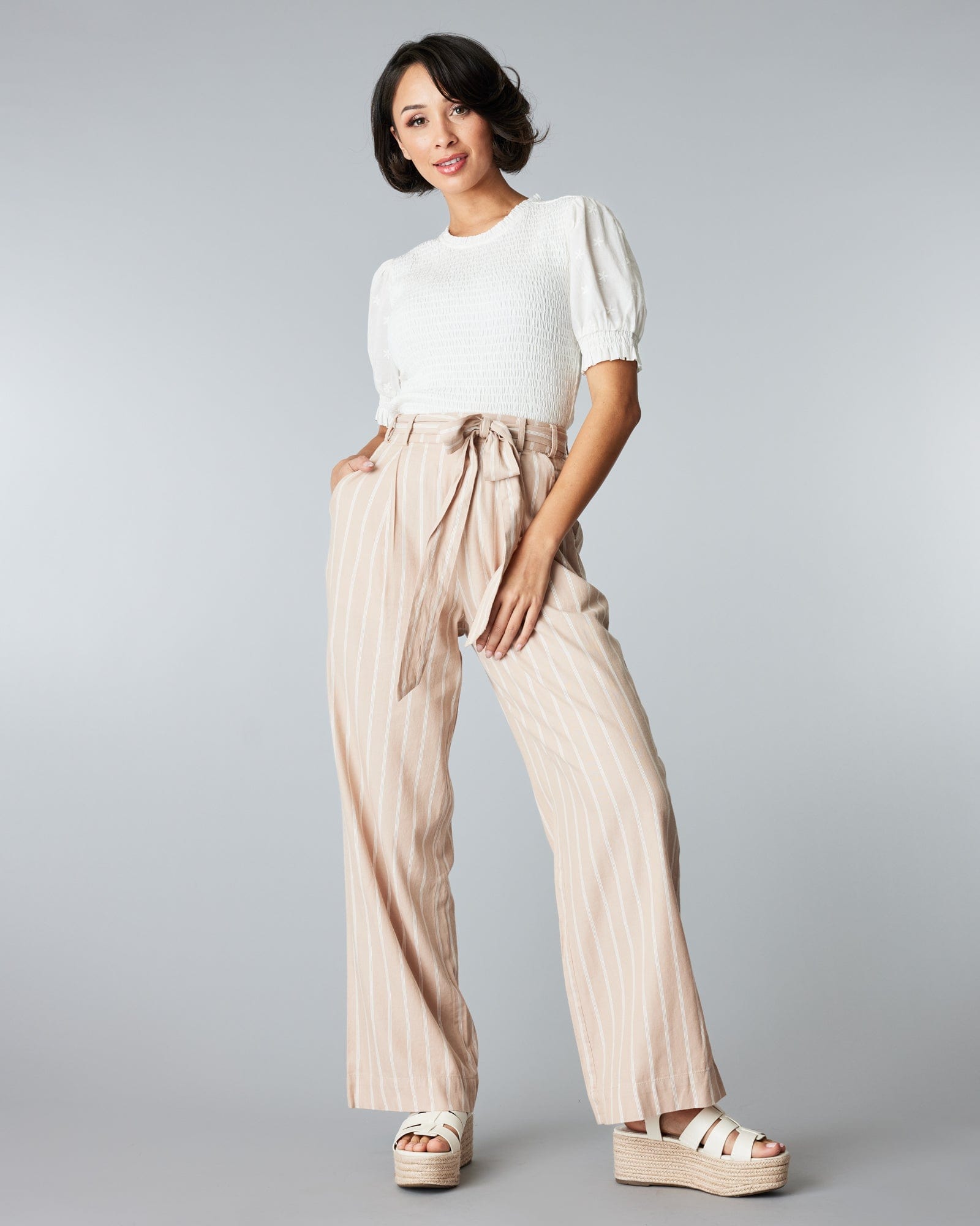 Woman in tan and white striped trousers