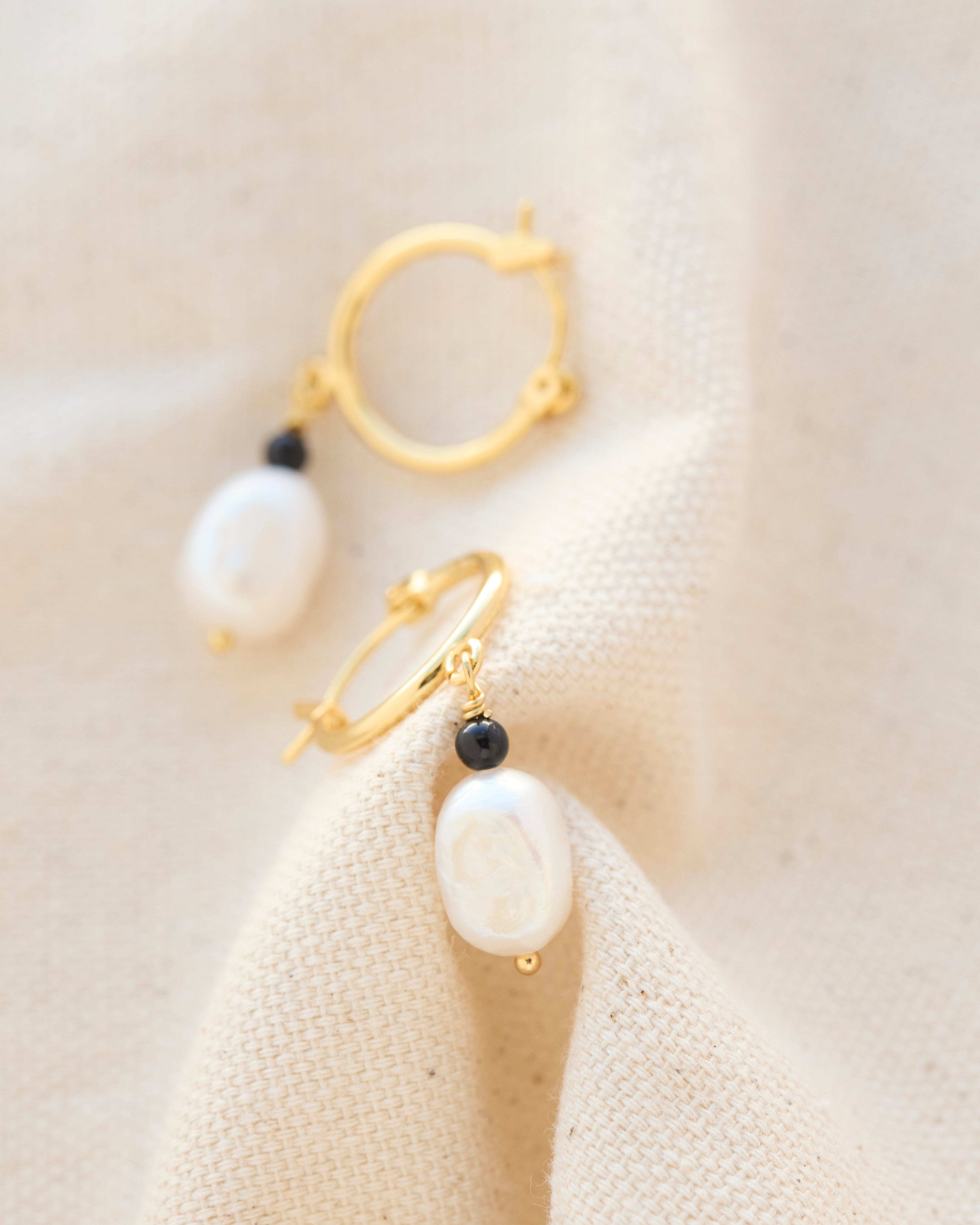 Gold hoop earrings with pearl bead. 