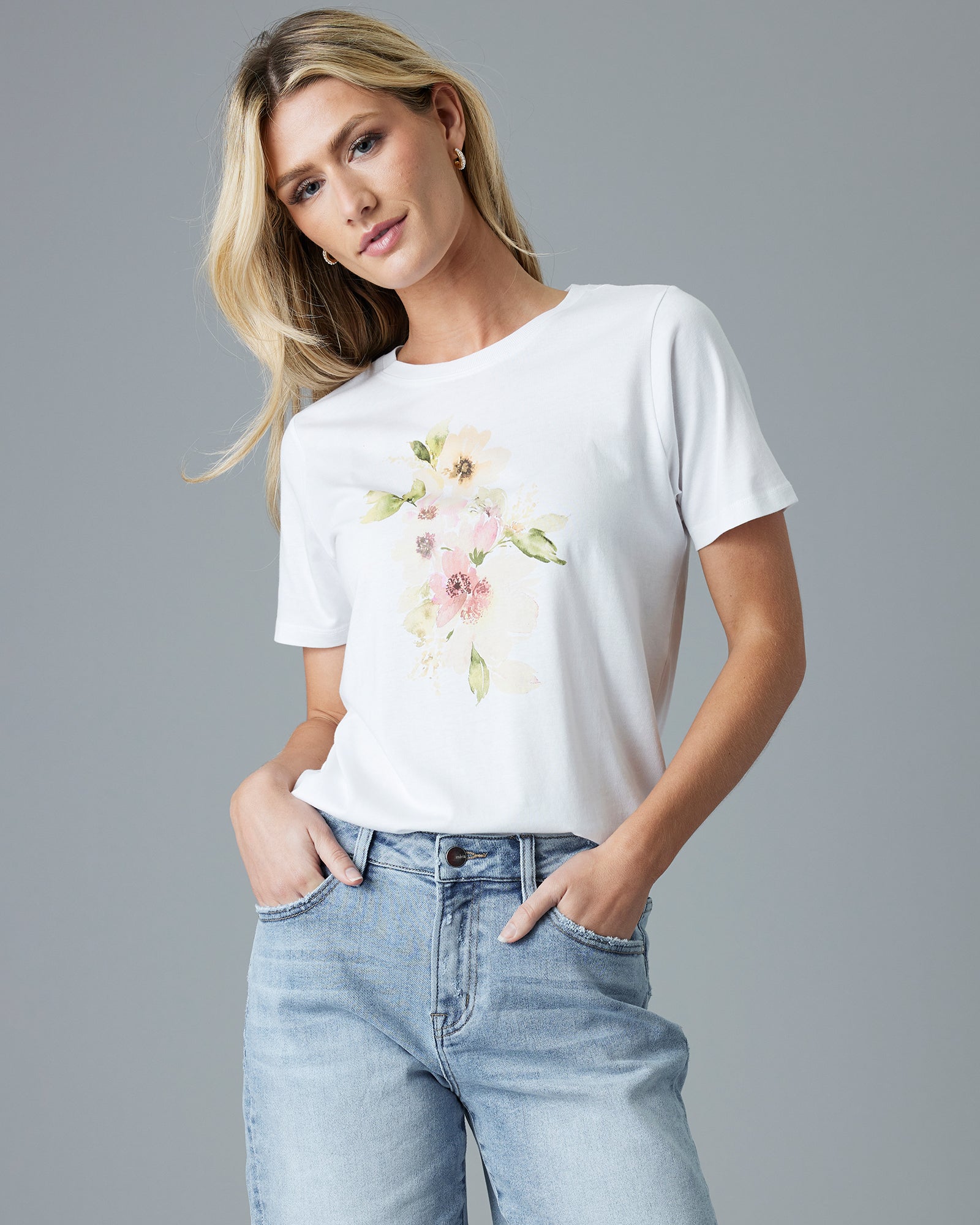 Woman in a white graphic tee with a watercolor flower on the top