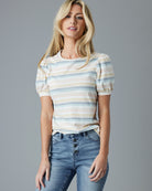Woman in a pastel rainbow striped short sleeve tee