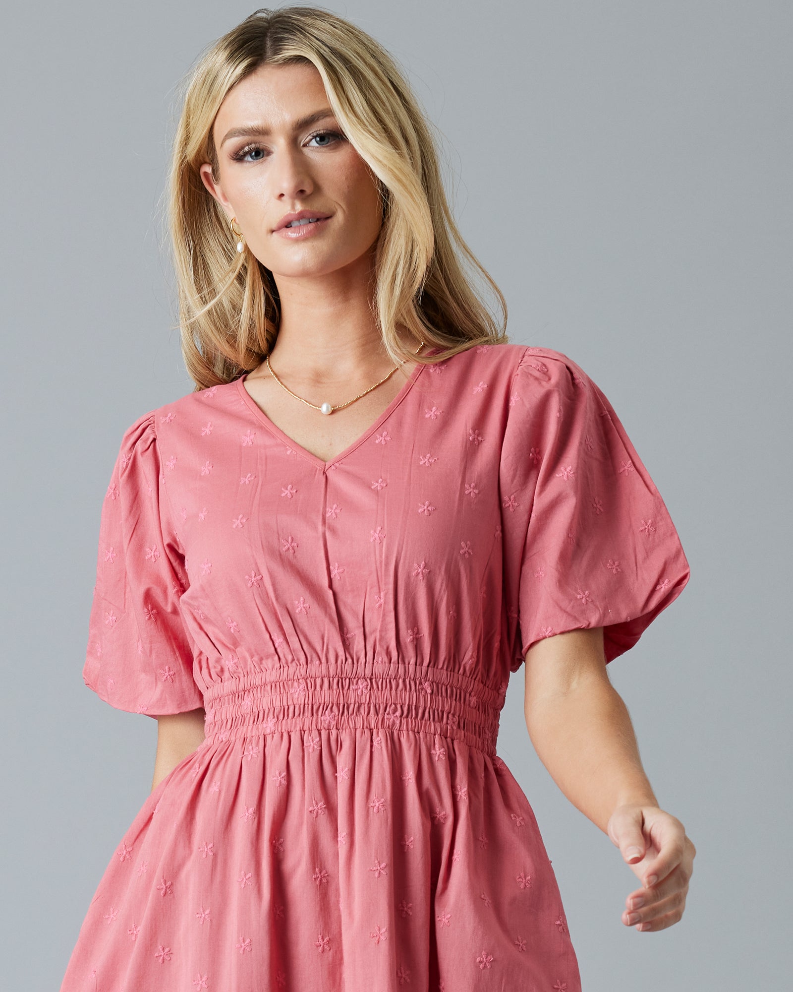 Woman in a rose color, embroidered, short sleeve knee-length dress