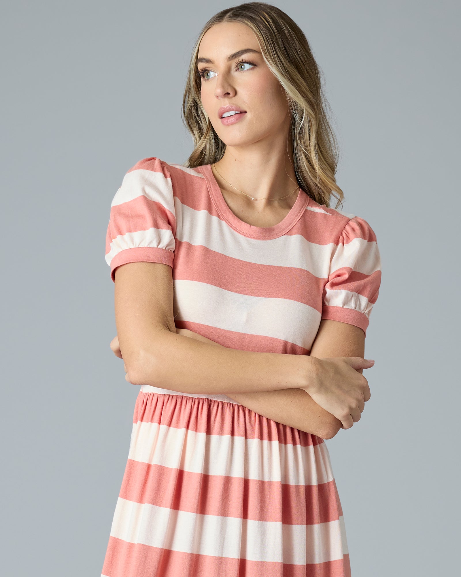 Woman in a pink and white striped a-line t-shirt dress