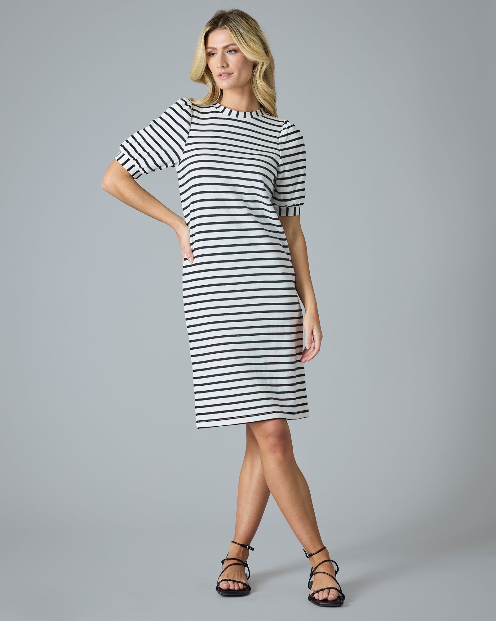 Woman in a short sleeve, navy and cream striped knee-length dress