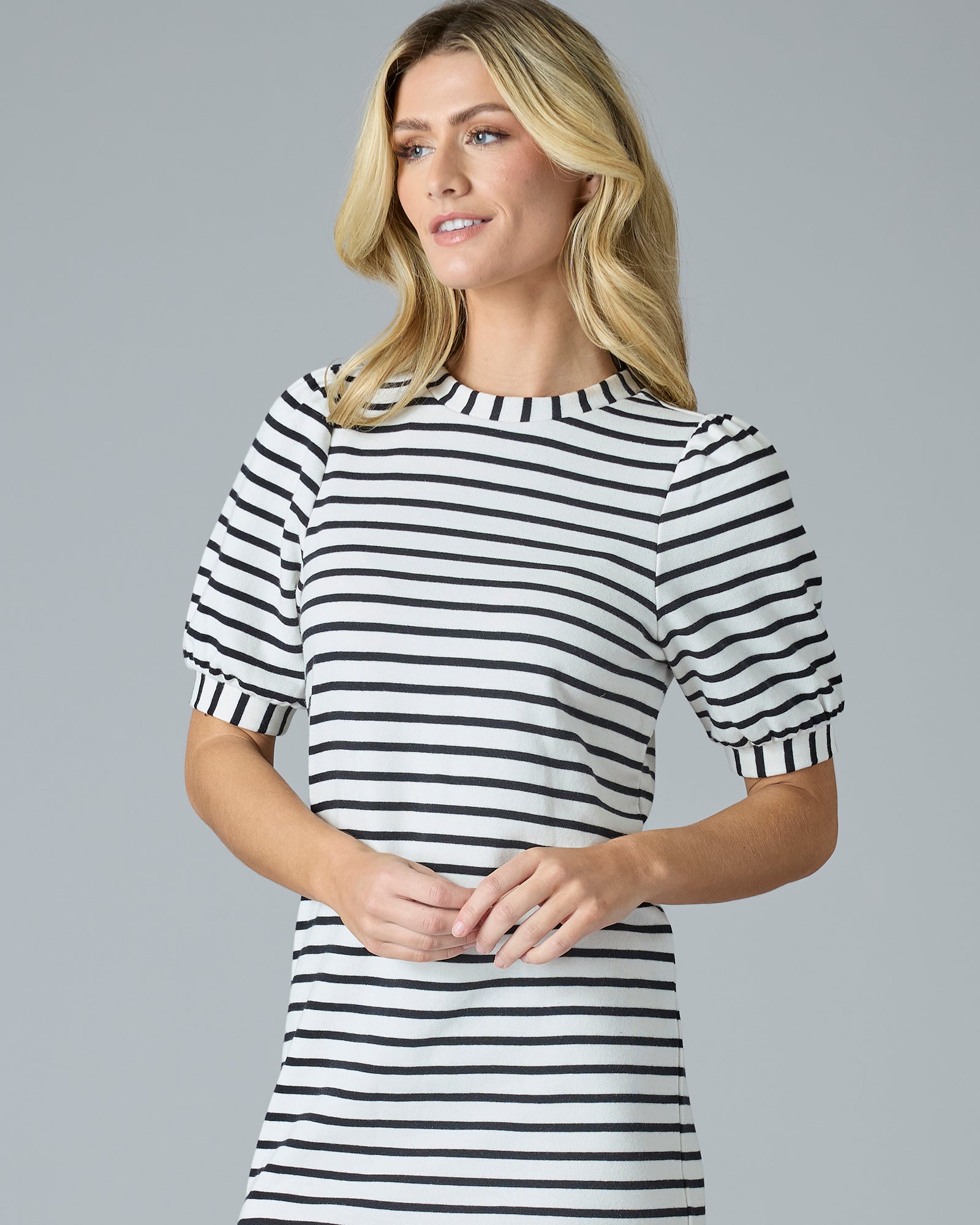 Woman in a short sleeve, navy and cream striped knee-length dress
