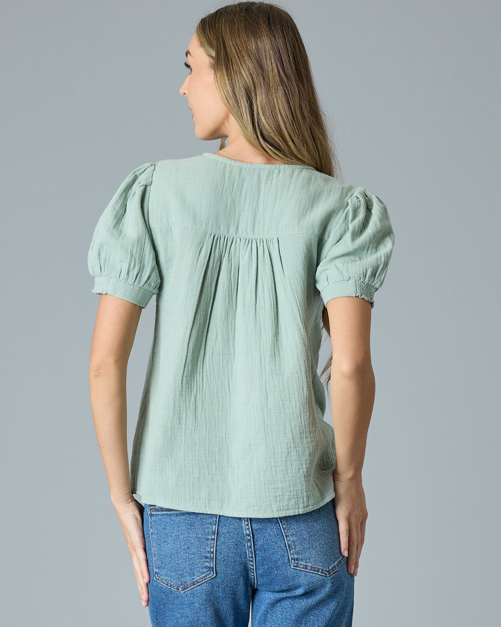 Woman in a green short sleeve button-down blouse