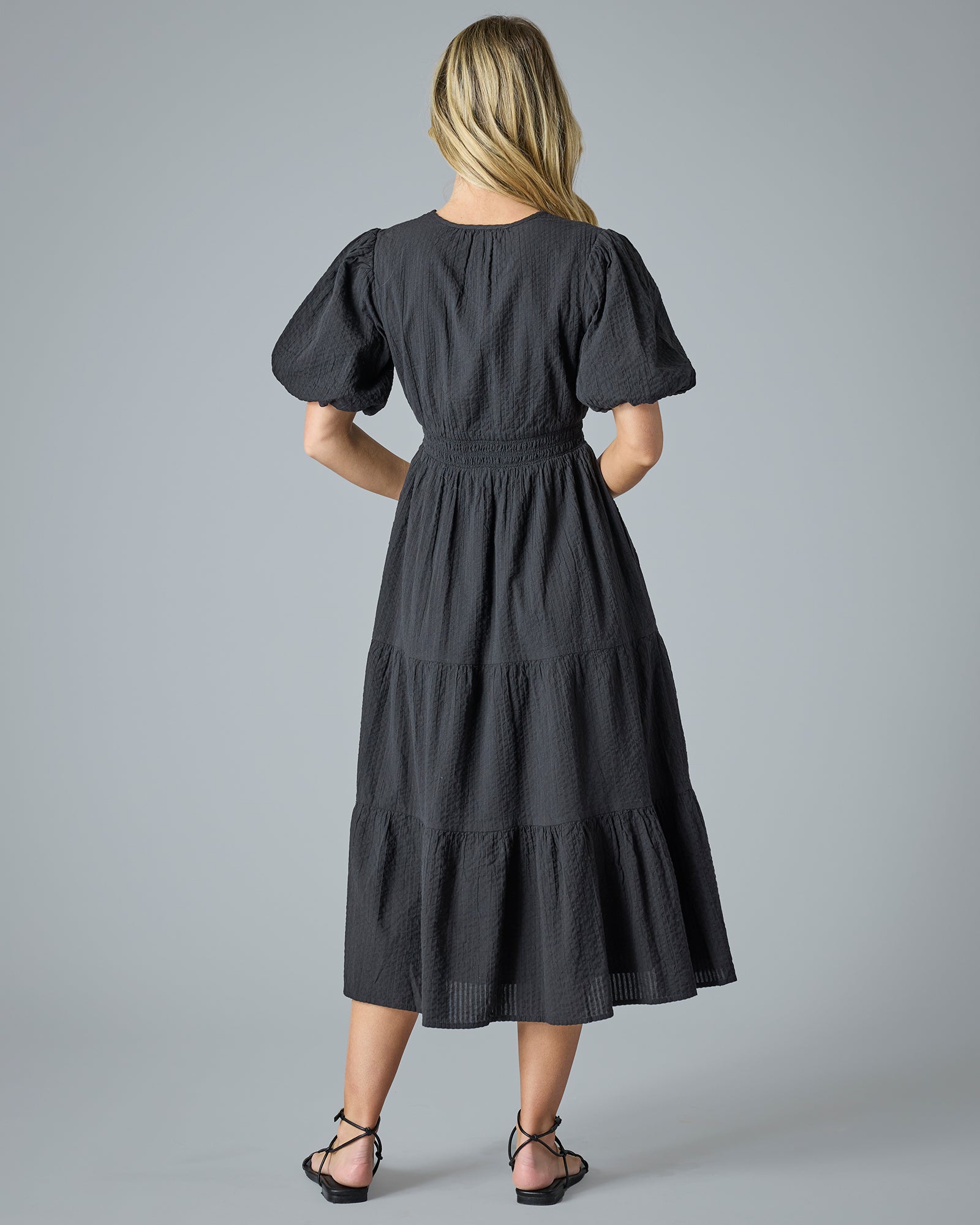 Woman in a black short sleeve midi-length dress