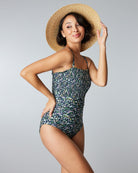 Woman in a one-piece swimsuit with smocking and floral pattern.