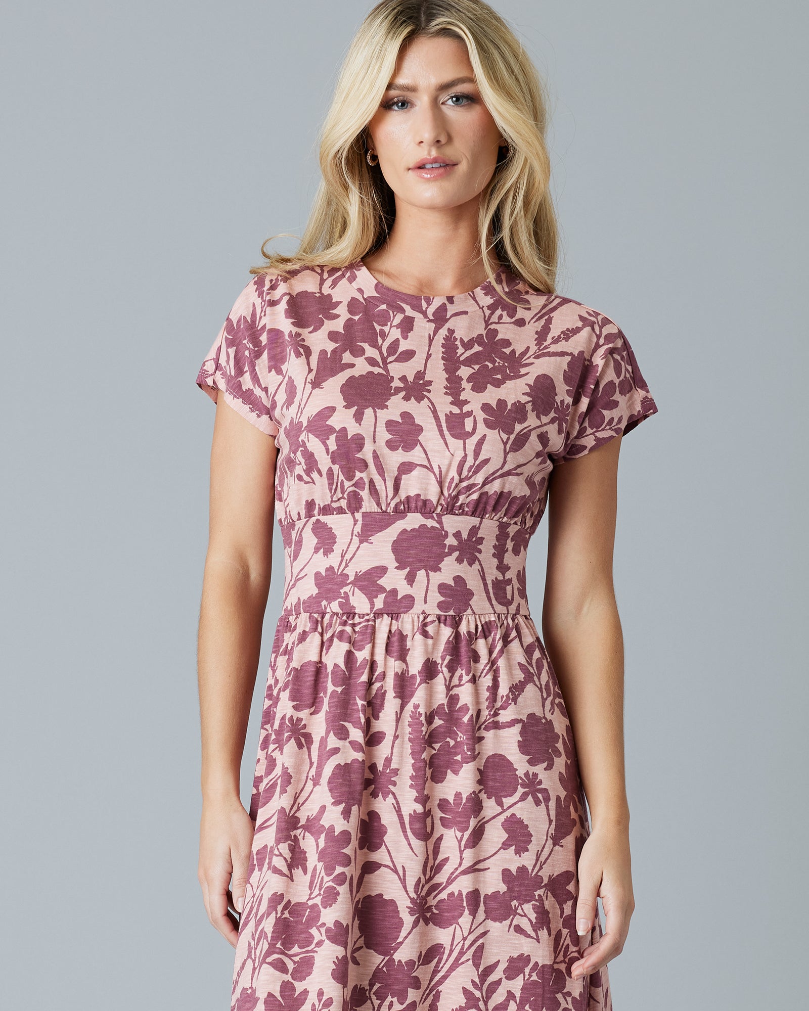Woman in a pink and purple, short sleeve, midi dress