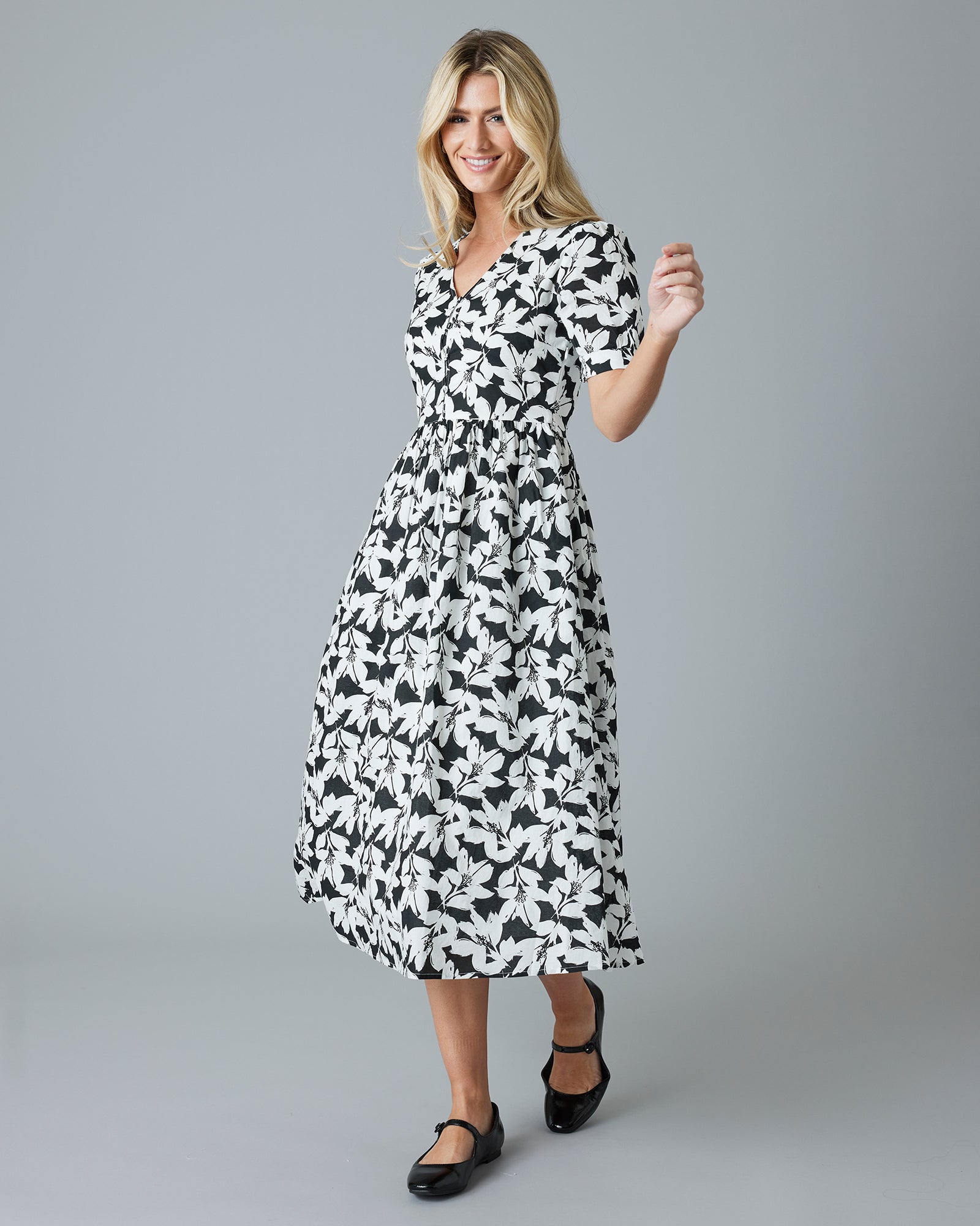 Woman in a black and white floral short sleeve midi-length dress