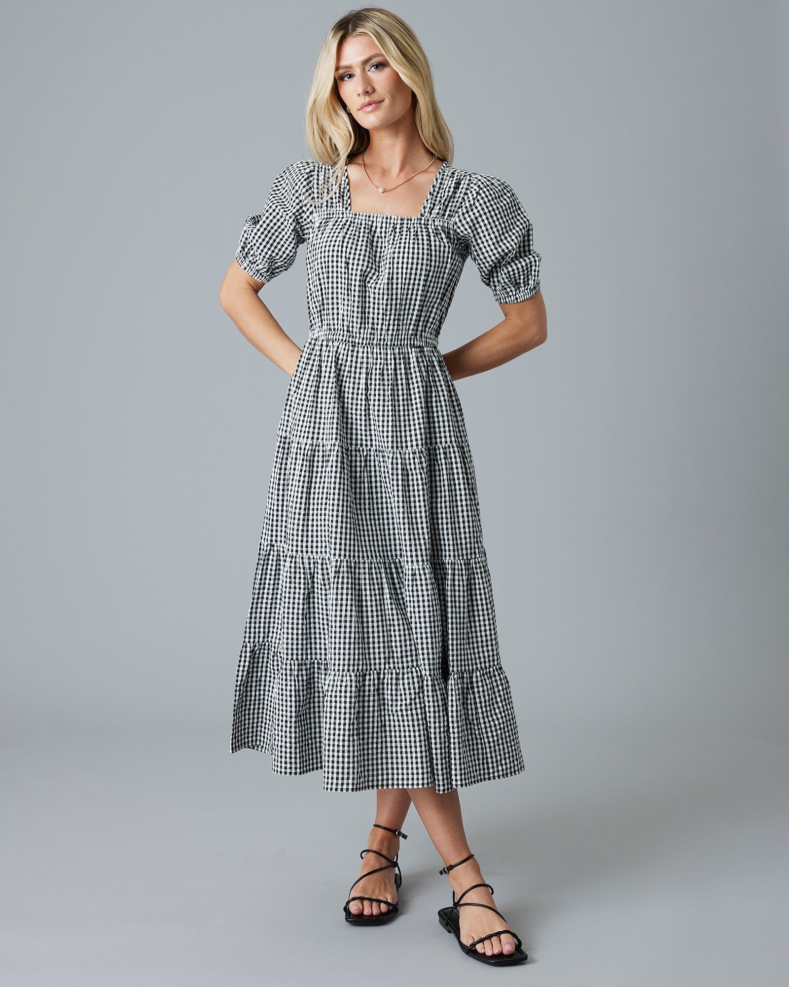 Woman in a black and white gingham print short sleeve midi dress