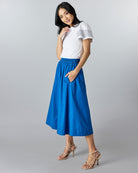 Woman in a blue, midi-length a-line skirt.