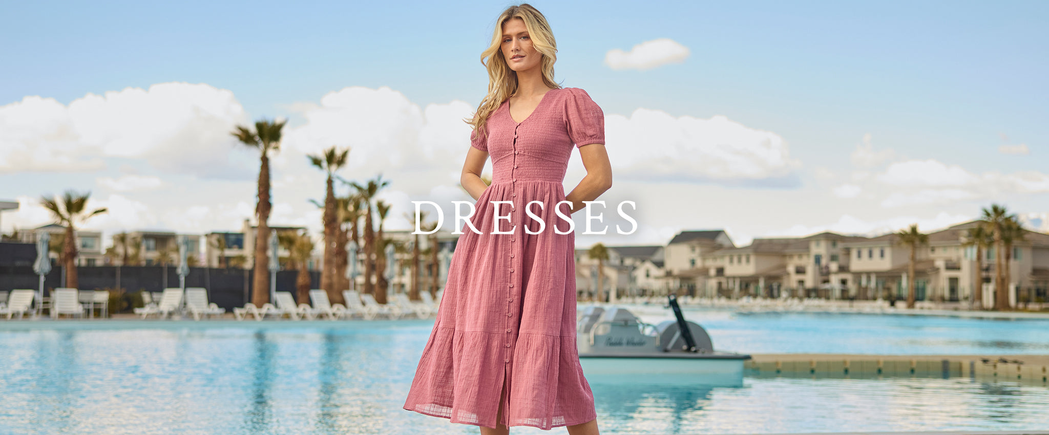 Woman by pool in a pink dress. Shop dresses.