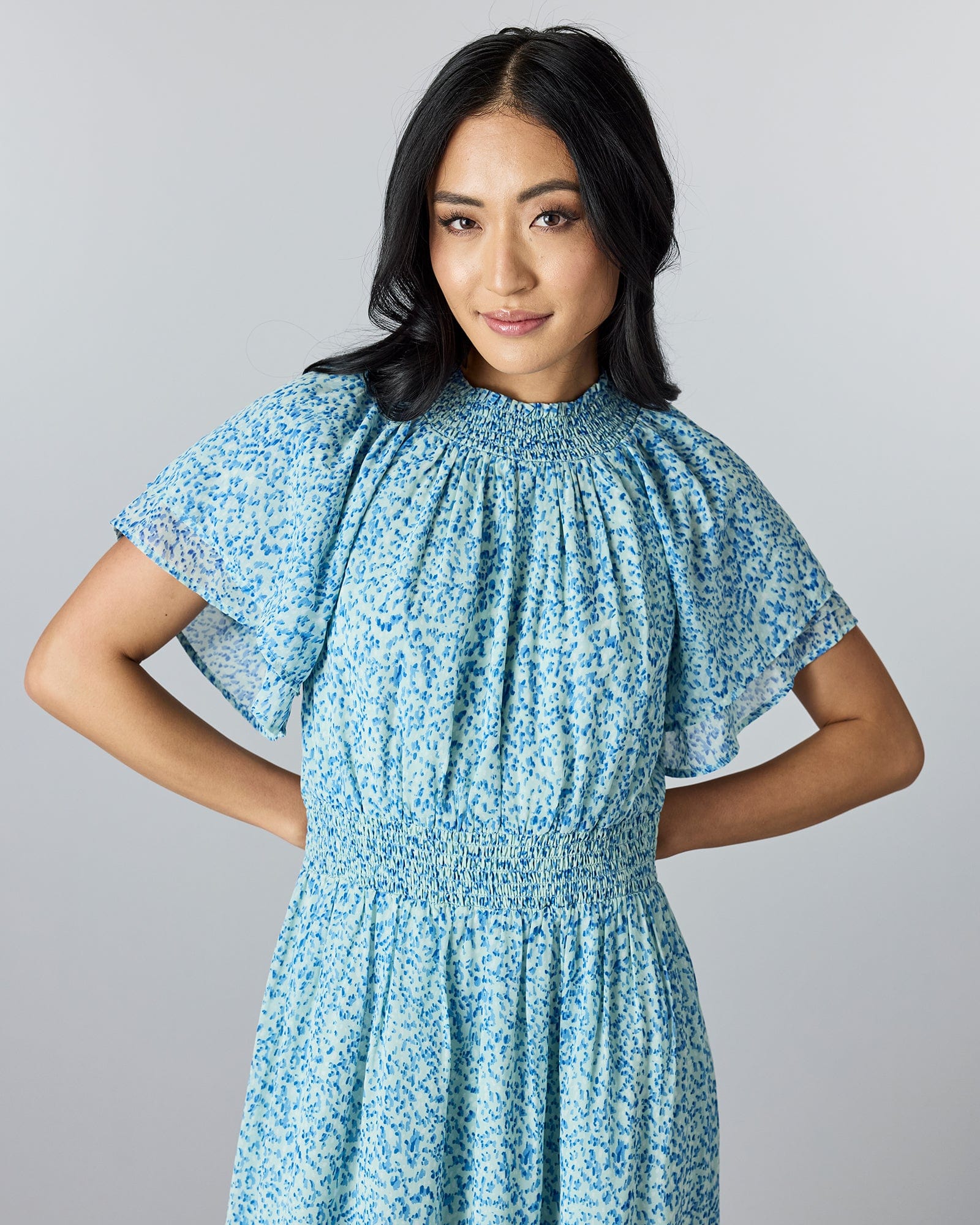 Woman in a blue floral, short sleeves, high neckline, maxi-dress.