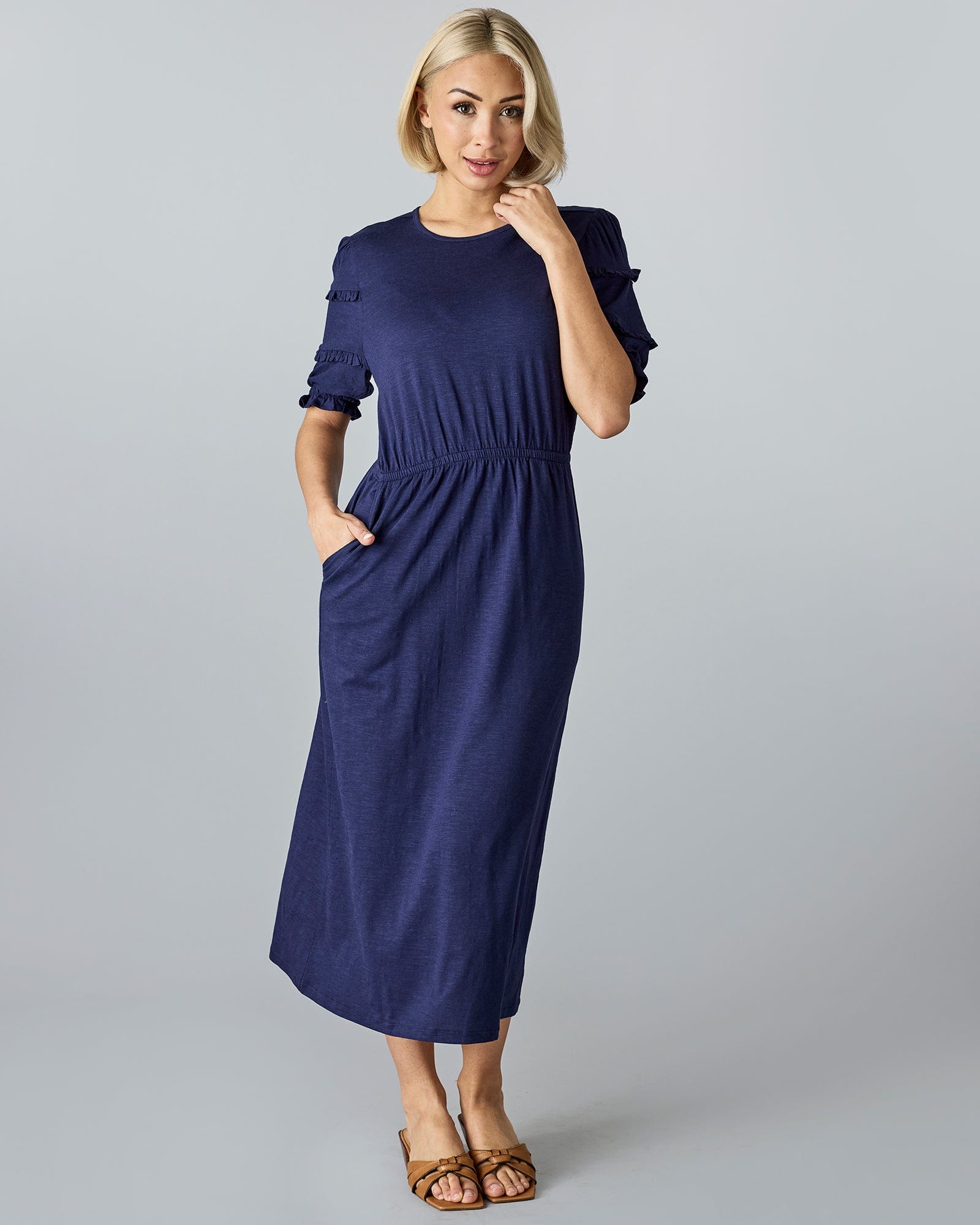 Woman in a blue, midi-length, short sleeve dress.